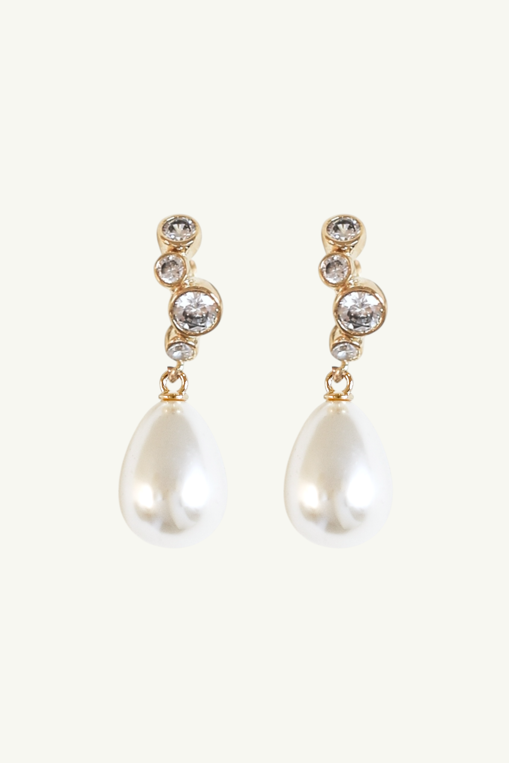 Flat photo of the gold stacked bezel pearl drop earrings by AB Ellie on white background