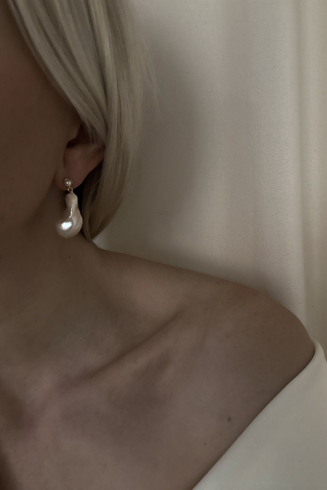 Close up photo of bride side profile with the statement baroque pearl earrings by AB Ellie with an off the shoulder dress