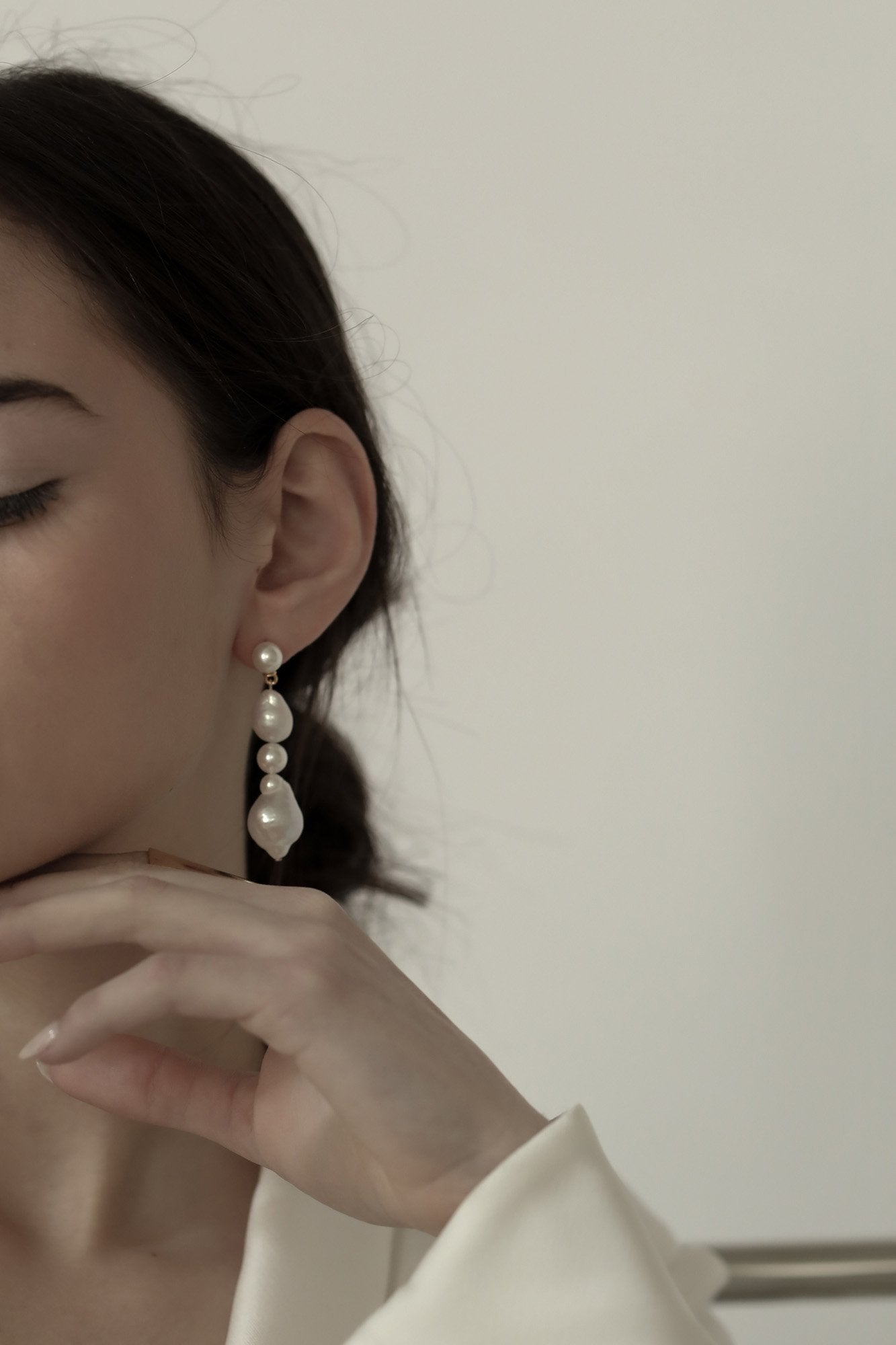Side view of brunette model wearing the freshwater triple pearl drop earring by A.B. Ellie