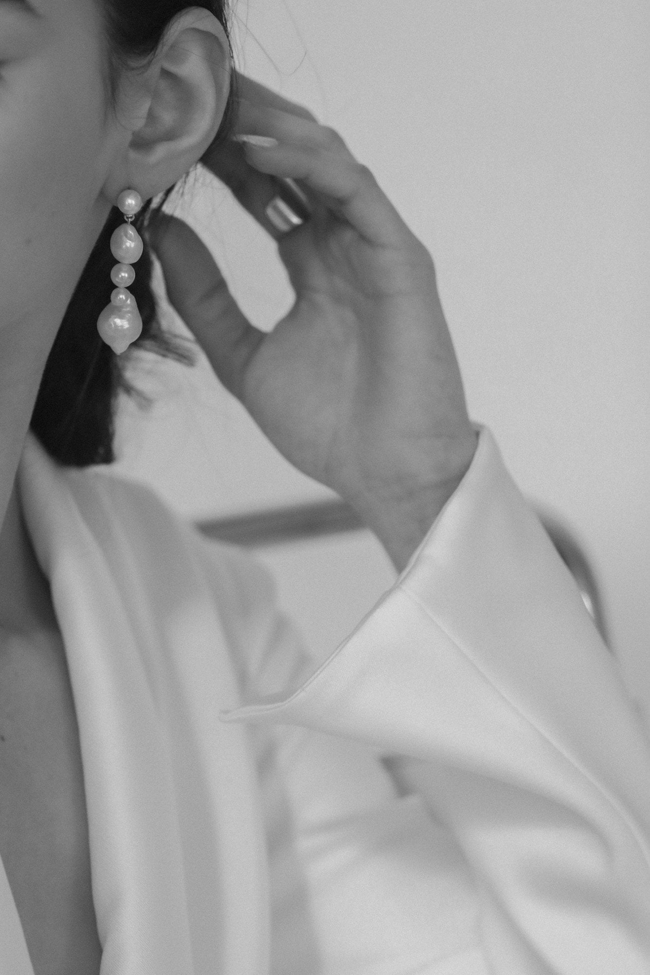 Close up side view of brunette model wearing the freshwater pearl triple drop earring by A.B. Ellie