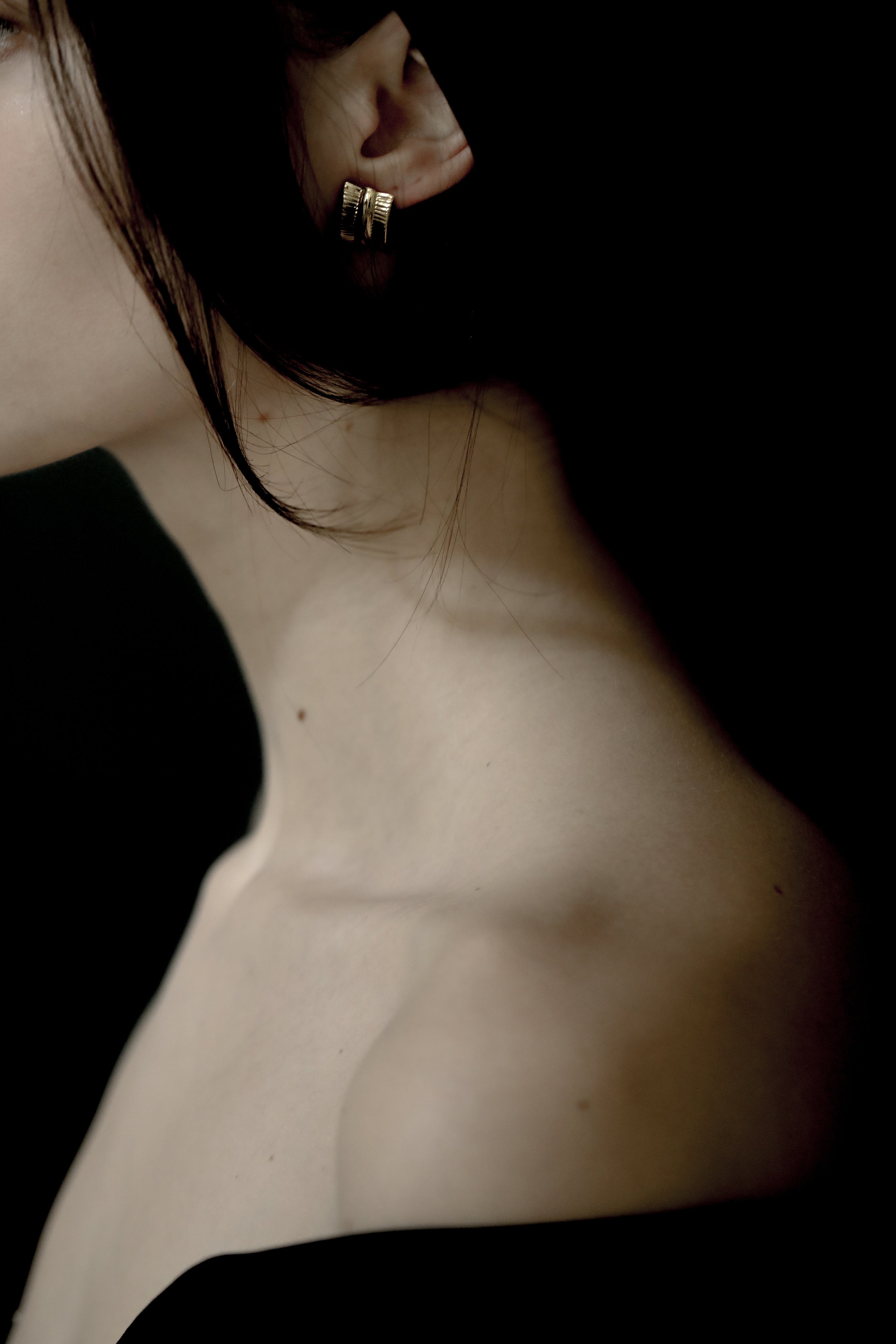 Close up photo of brunette woman wearing the ribbed channel sterling silver earring by AB Ellie
