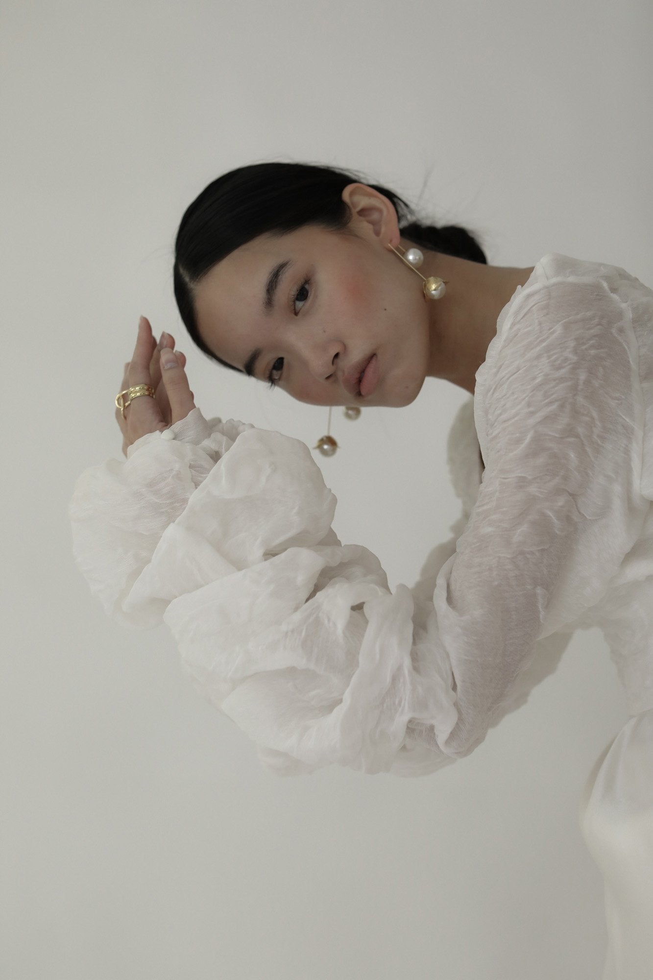 Dark haired bride wearing the Bardot Pearl drop earrings by AB Ellie with statement sleave bridal gown.