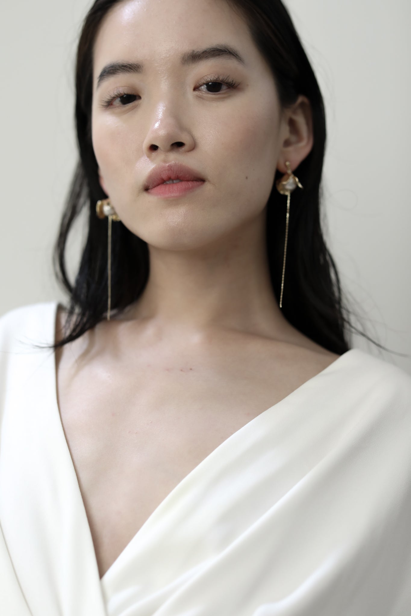Front view of bride with dark hair wearing the Bardot gold pearl earring strands by AB Ellie Jewelry