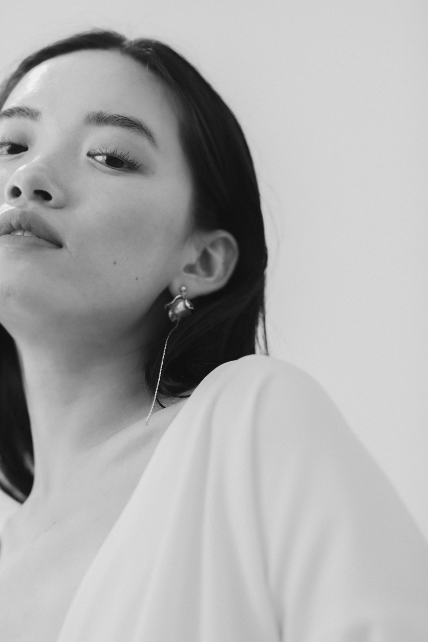 Black and white front image from below of dark haired bride wearing the Bardot strand pearl bridal earrings by AB Ellie