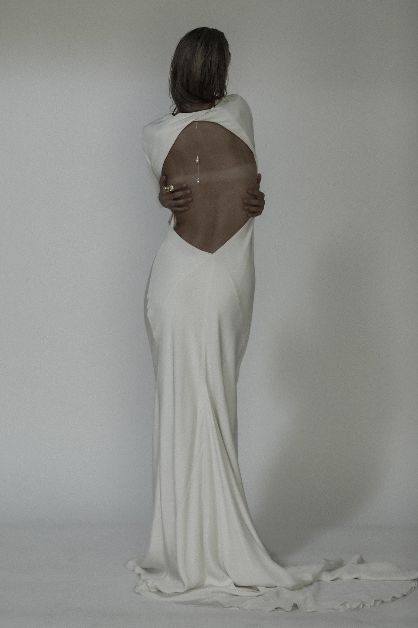 Back view of blonde bride wearing the baroque pearl lariat necklace by AB Ellie, paired with an open back wedding dress