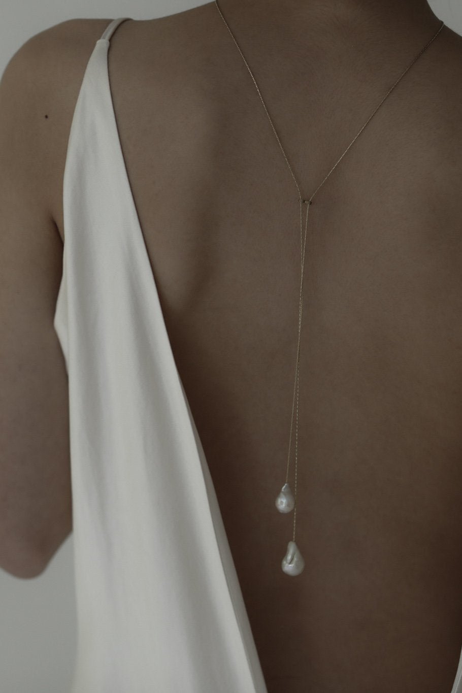 Bride wearing the baroque pearl lariat necklace by AB Ellie paired with an open back wedding dress