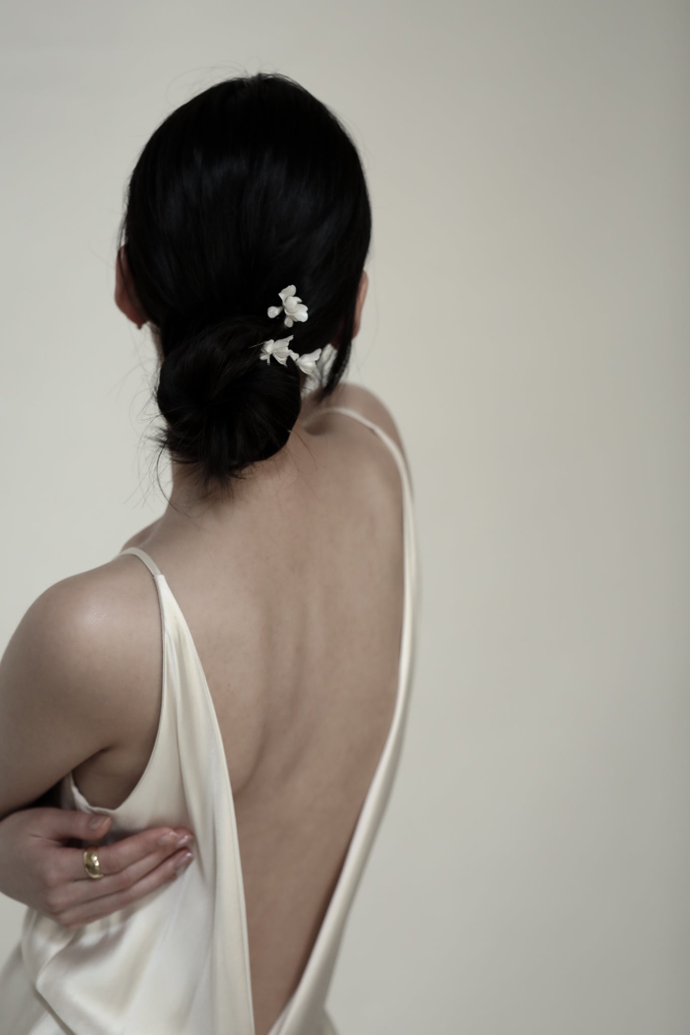 Photo of dark haired bride wearing the Blossom bridal hairpin trio by AB Ellie with open back dress