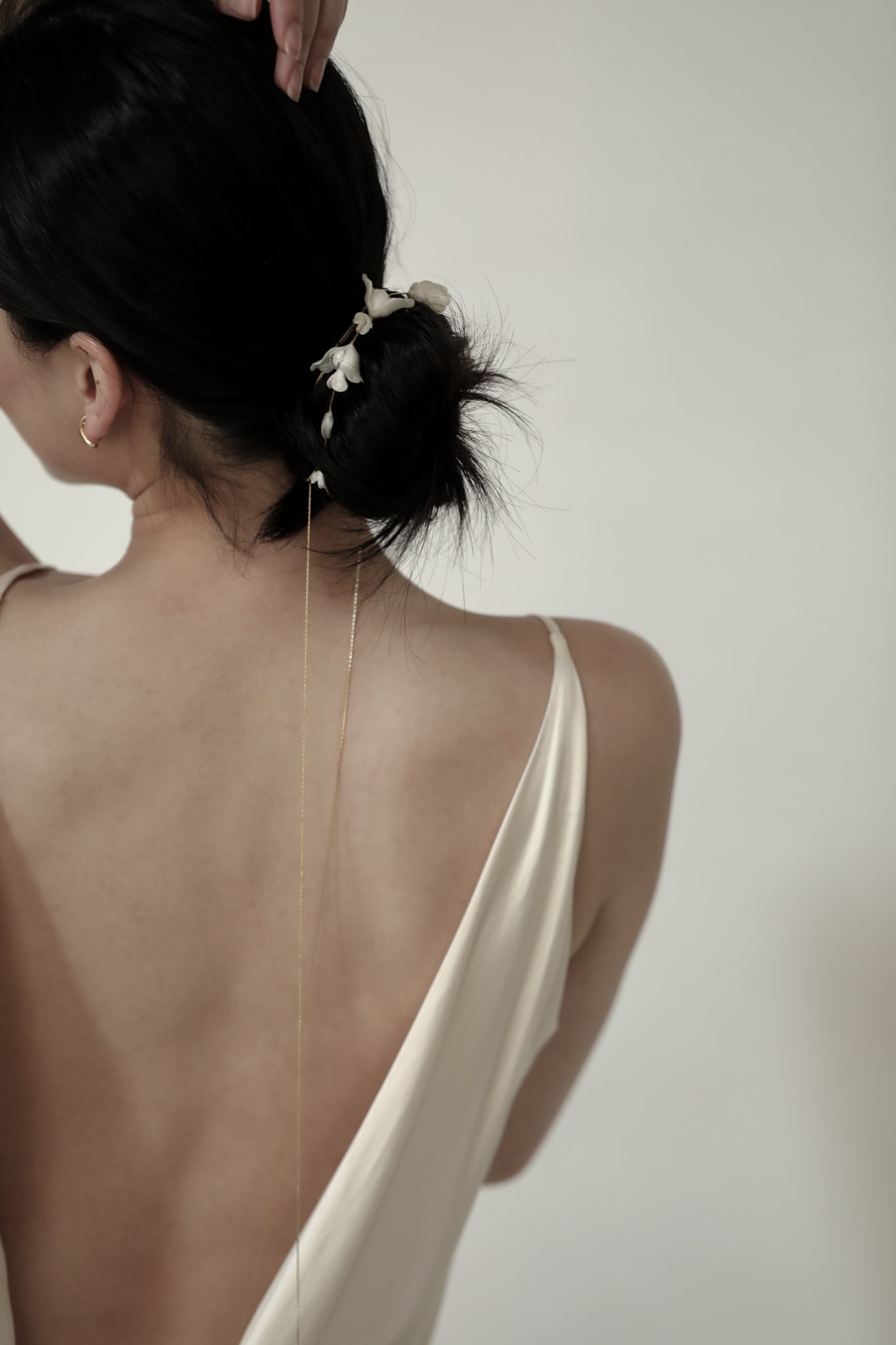 Bride with open back wedding dress wearing the blossom gold and floral wrap styled in her hair