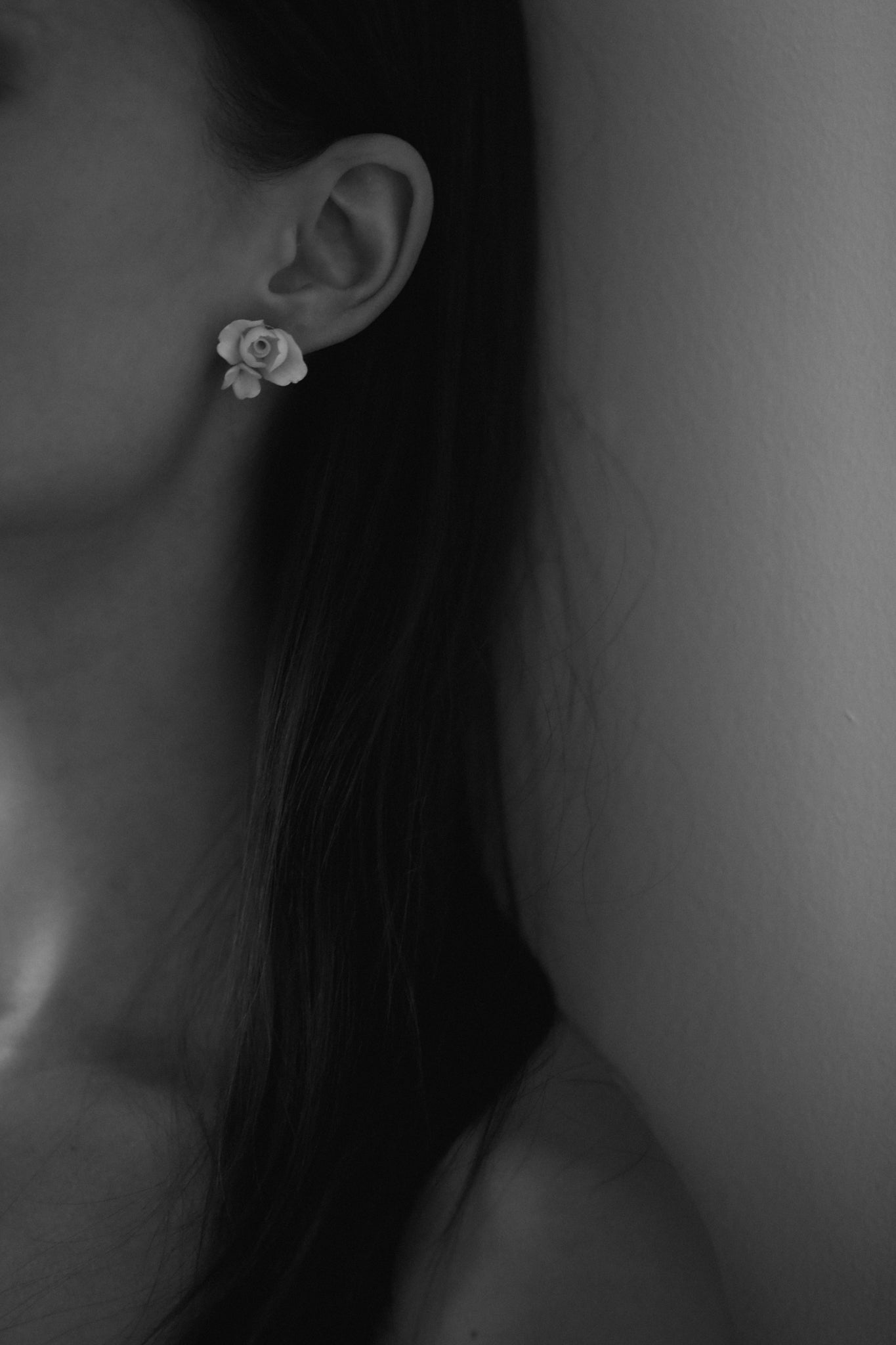 A close-up image of a dark haired bride wearing the ivory blossom floral stud earring by AB Ellie