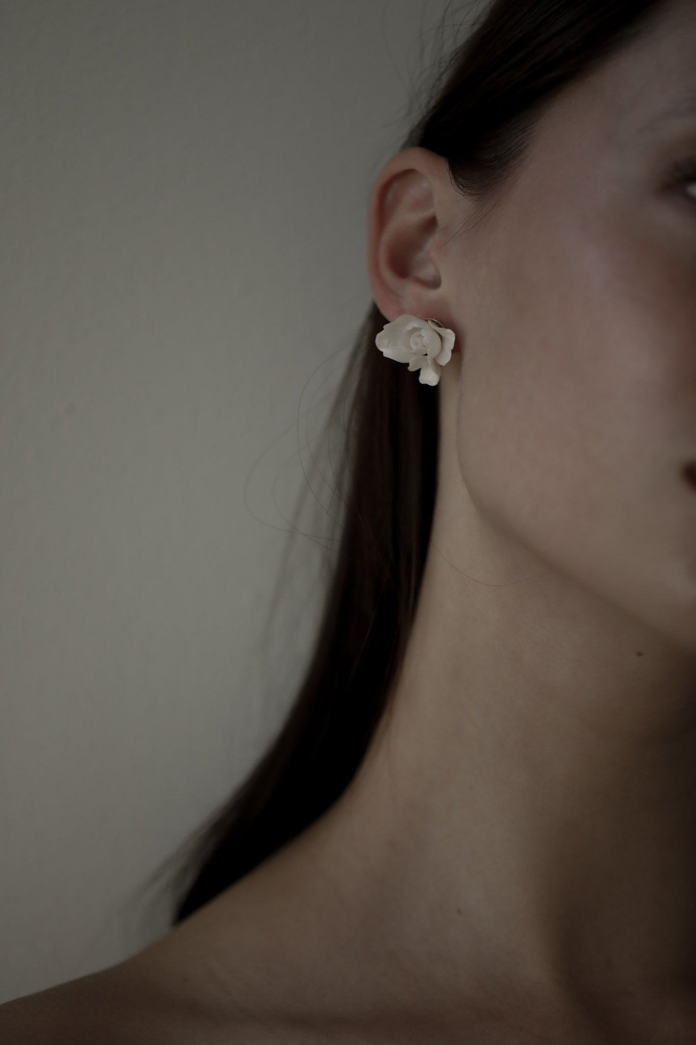 Close up side view of dark haired bride wearing the ivory Blossom floral stud earrings by AB Ellie
