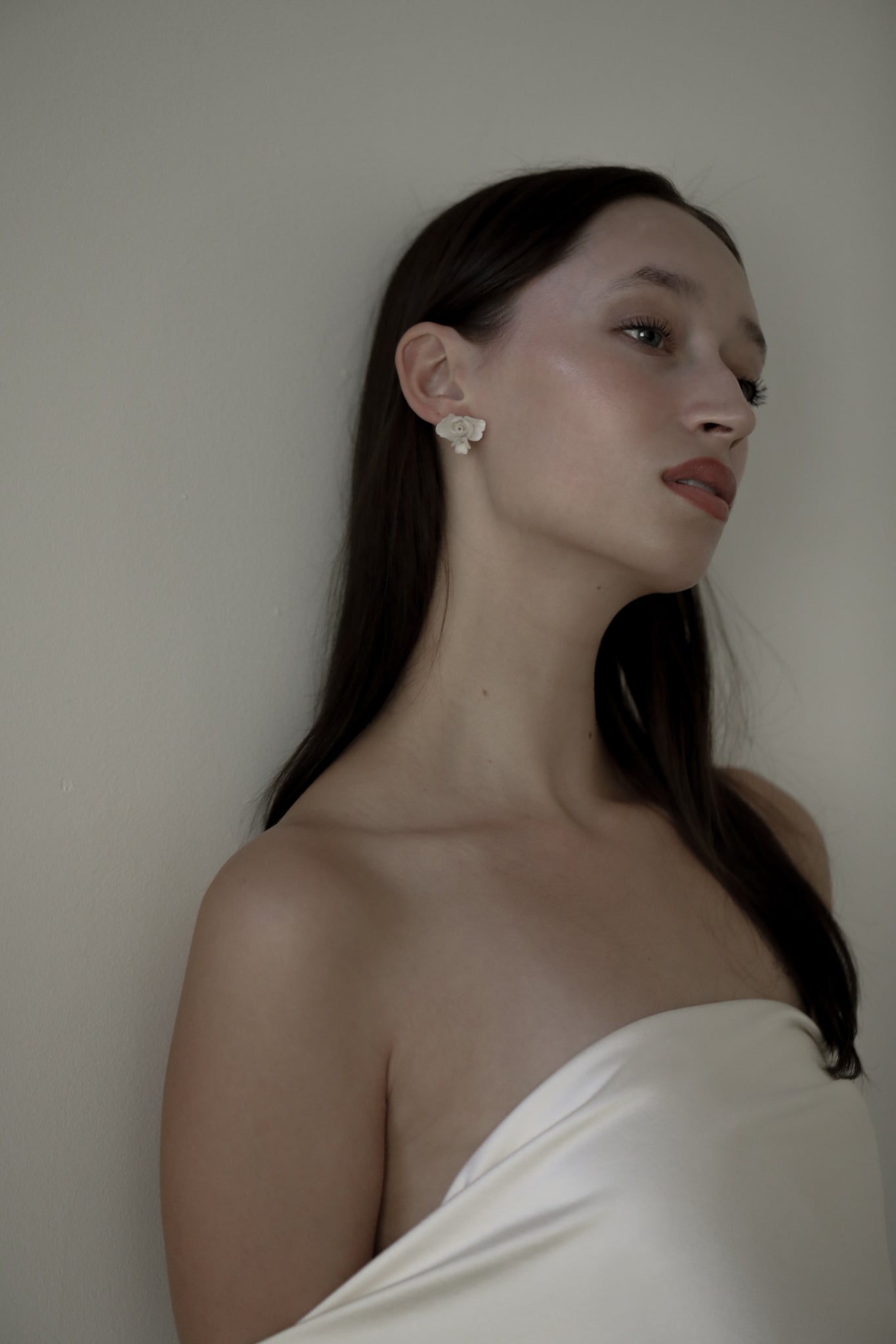 Dark haired bride wearing the ivory blossom floral stud earrings by AB Ellie with a strapless wedding dress