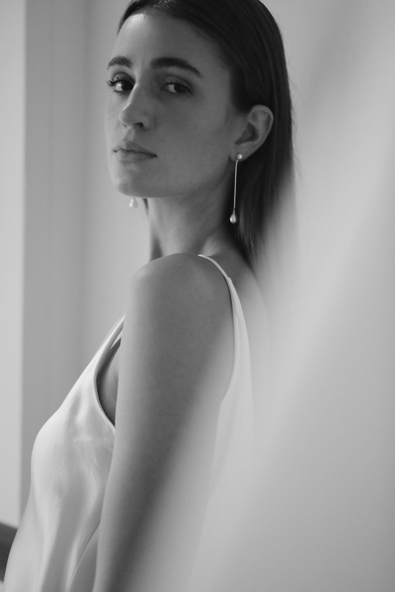 Black and white portrait of bride wearing a 2 in 1 pearl strand earring by Studio Bride