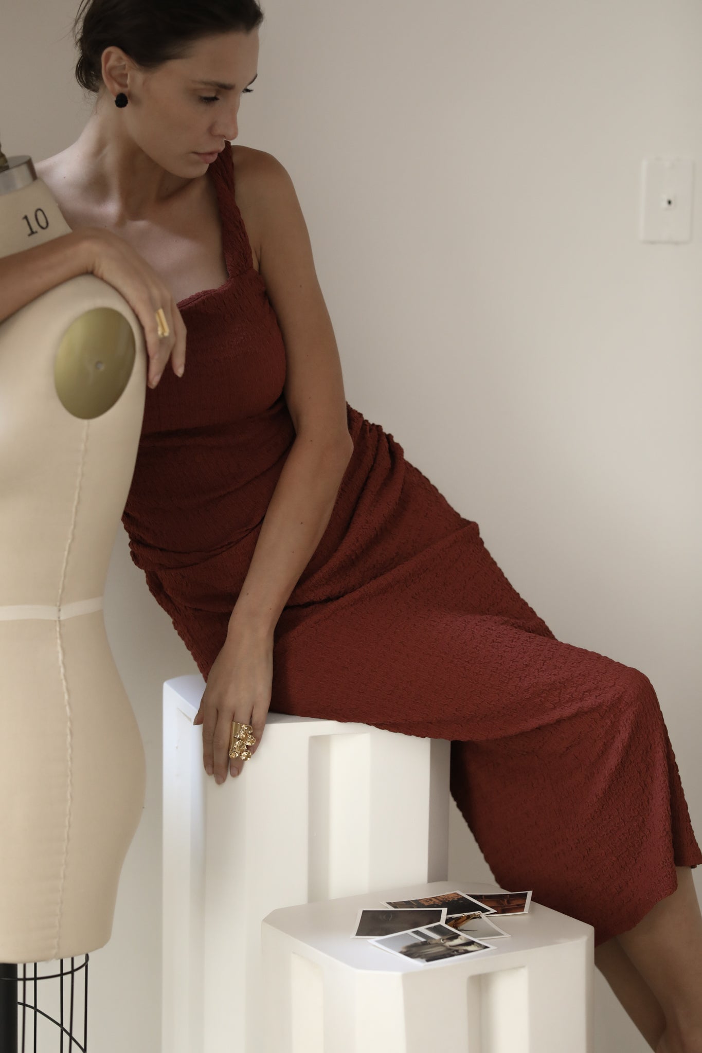 Brunette wearing black Celine stud earrings paired with a burgundy dress