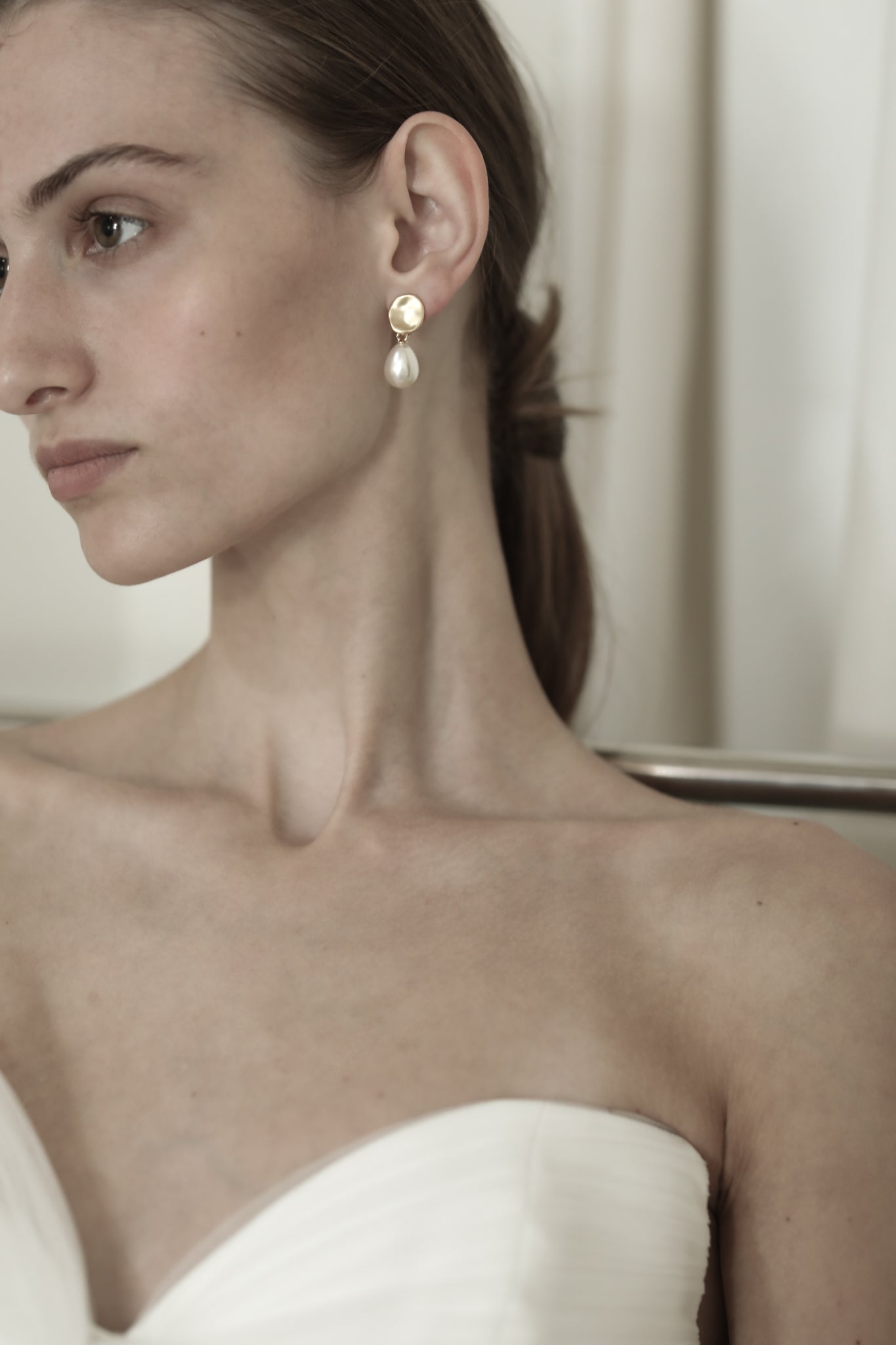 Front side photo of bride wearing the gold mini sculptural pearl drop earrings by AB Ellie