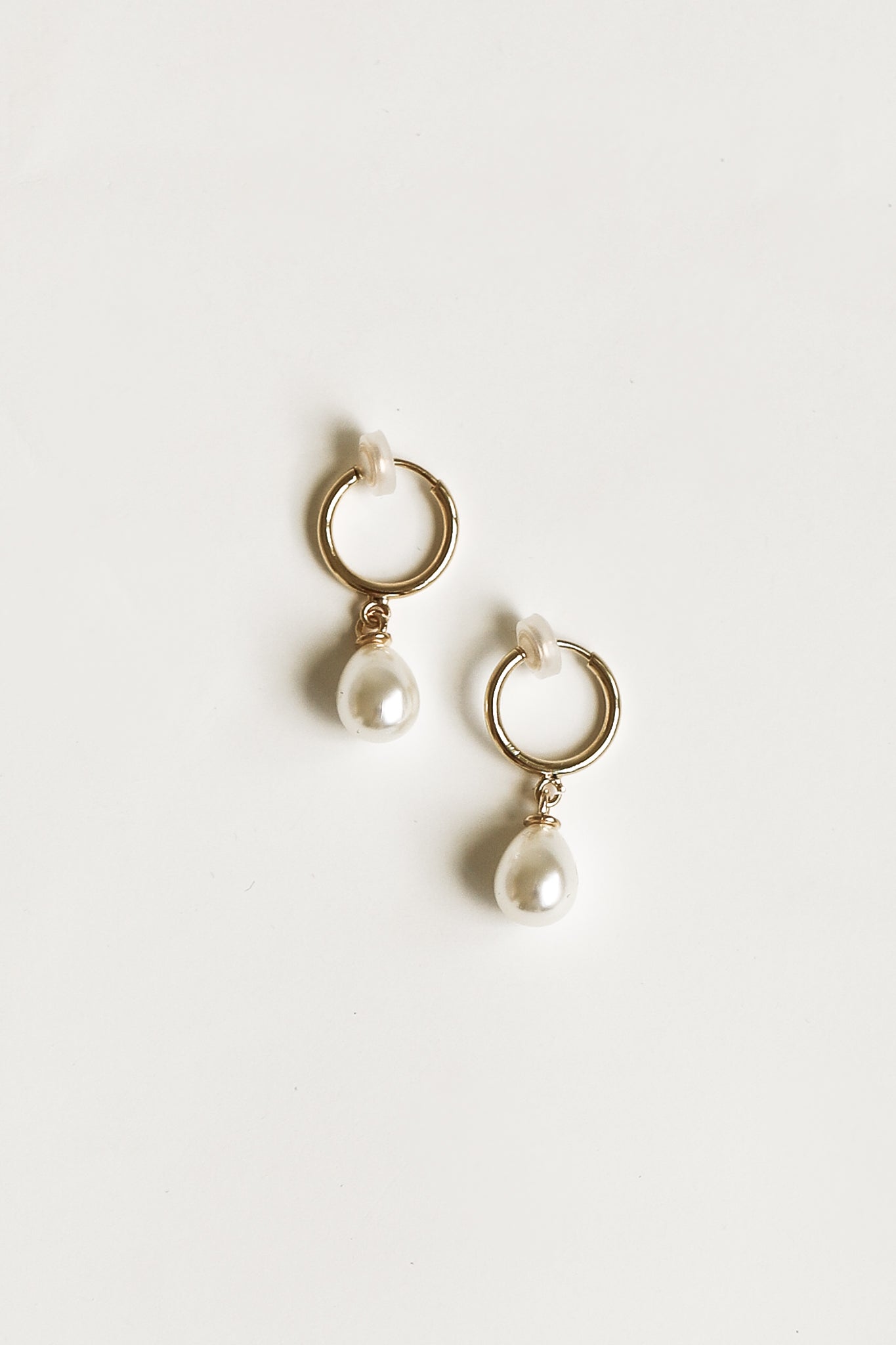 Flat photo of the gold pearl hoop earrings by AB Ellie on white background