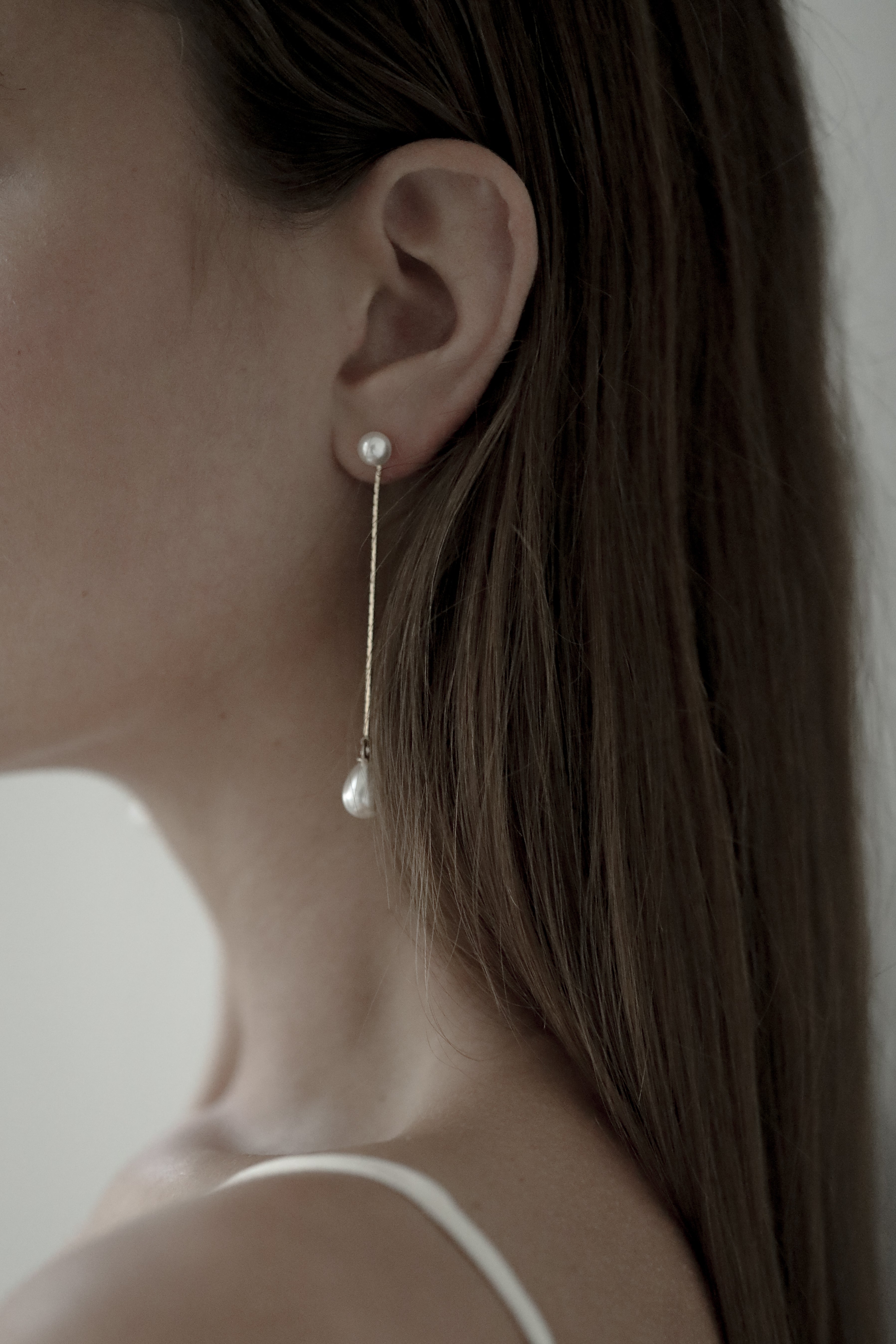 Close-up of a bride wearing pearl drop earrings by Studio Bride Jewelry