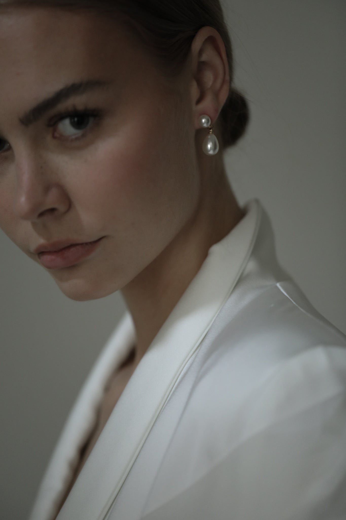Brunette model wearing wedding suit coat with Double Pearl earrings