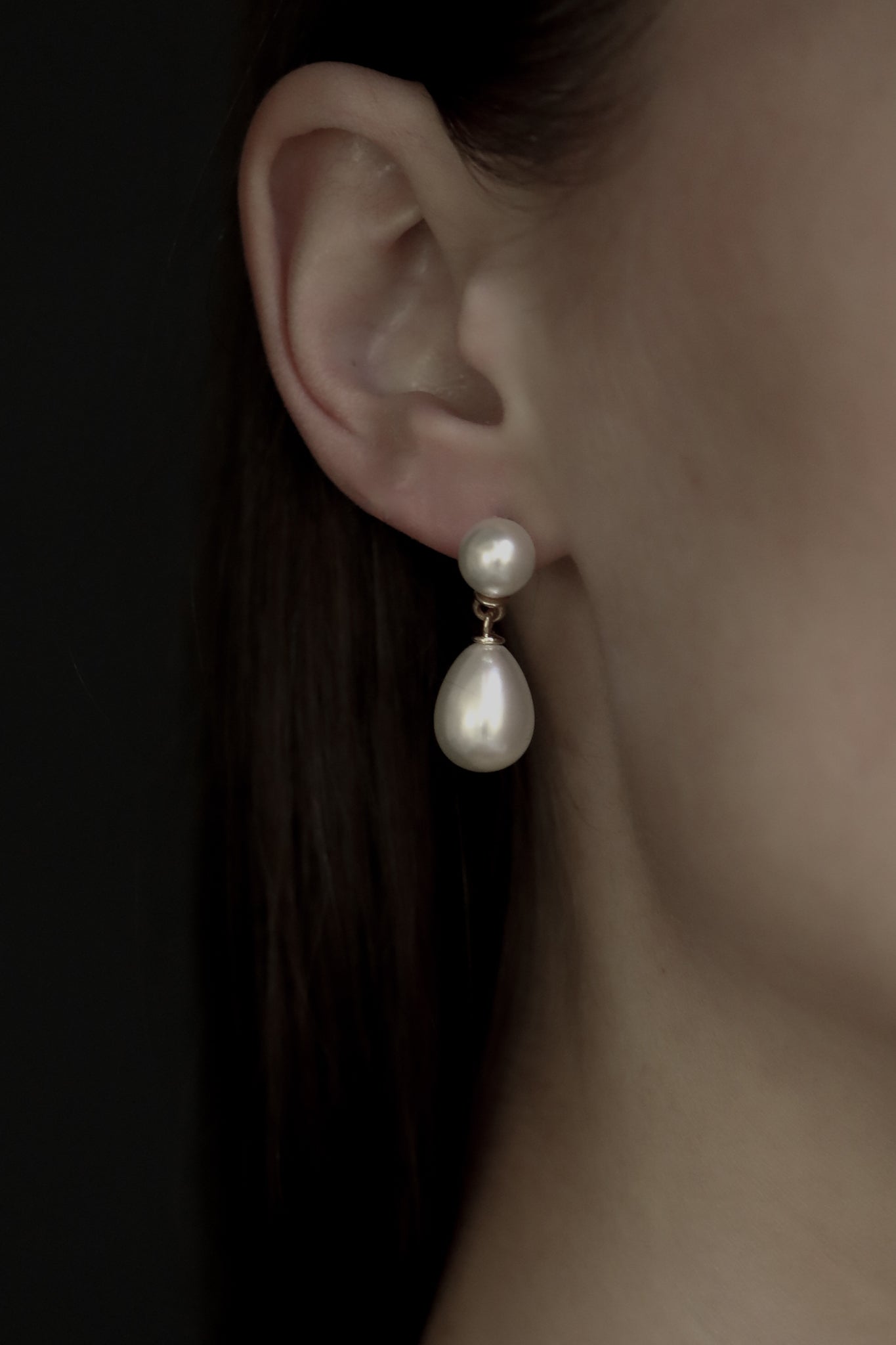 Close up of Gold Pearl double drop earrings on model