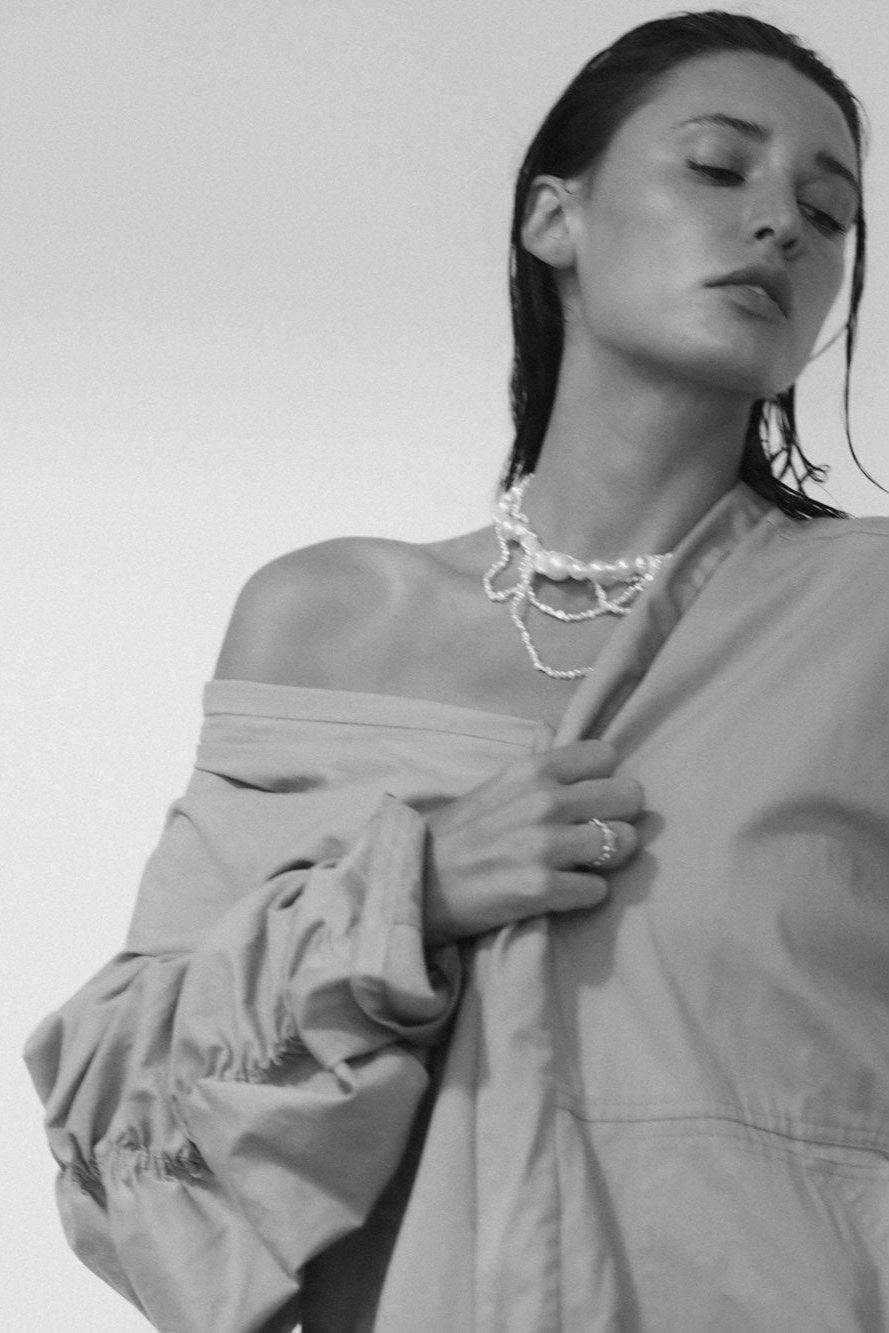 Black and white image of dark haired woman wearing the freshwater pearl cascading necklace by AB Ellie