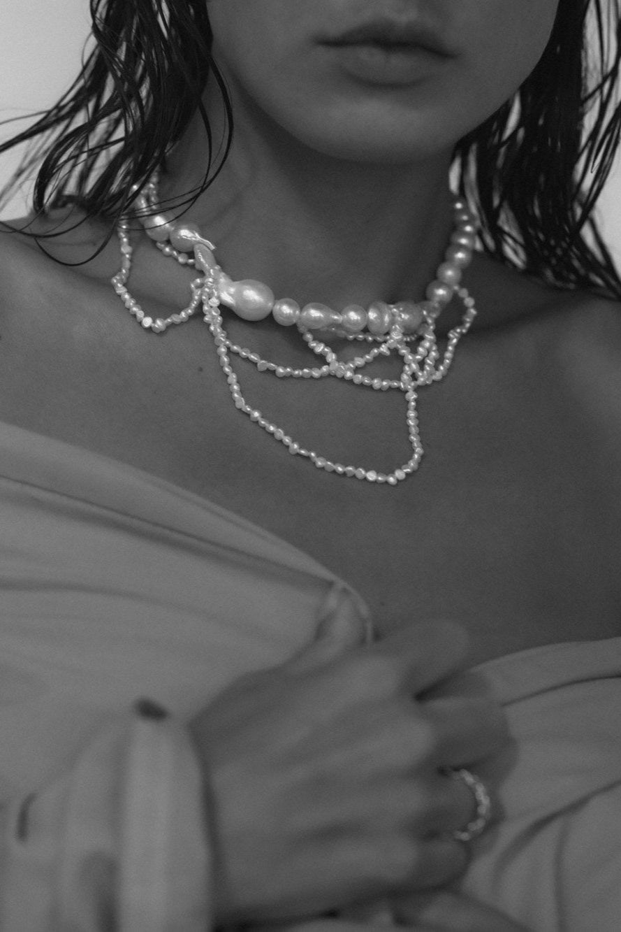Black and white close up image of bride wearing the cascading  freshwater pearl necklace by AB Ellie