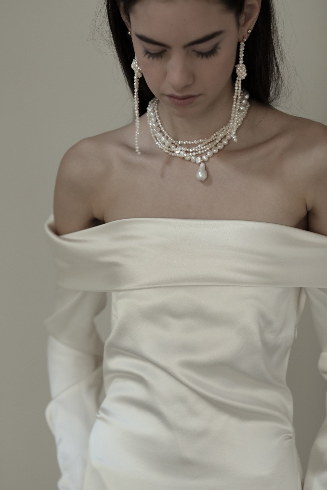 Front view photo of brunette bride wearing an off shoulder gown with the kiontted freshwater pearl earrings by AB Ellie