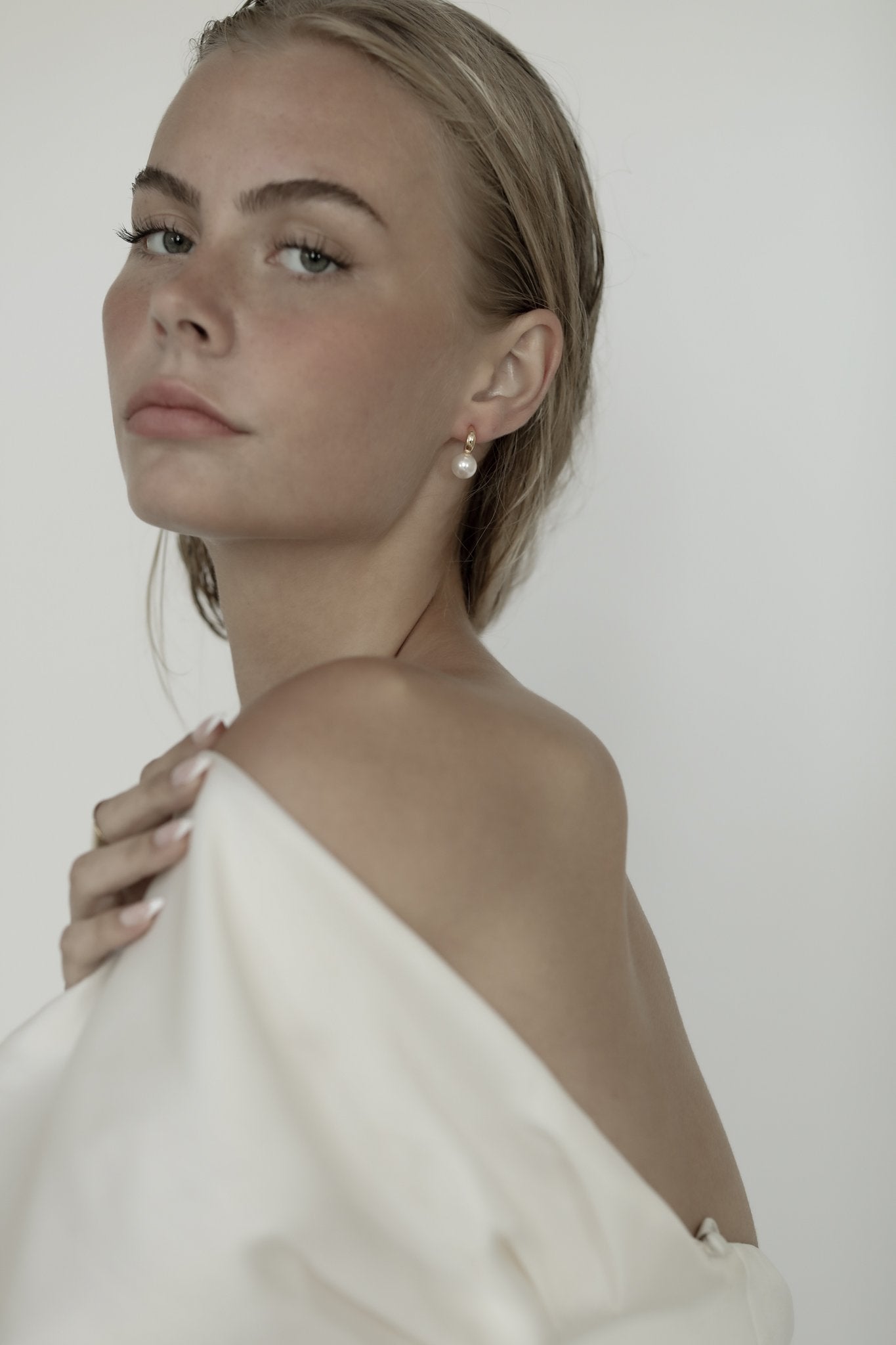 Blonde bride wearing the crescent hoop pearl earrings by AB Ellie with off the shoulder dress