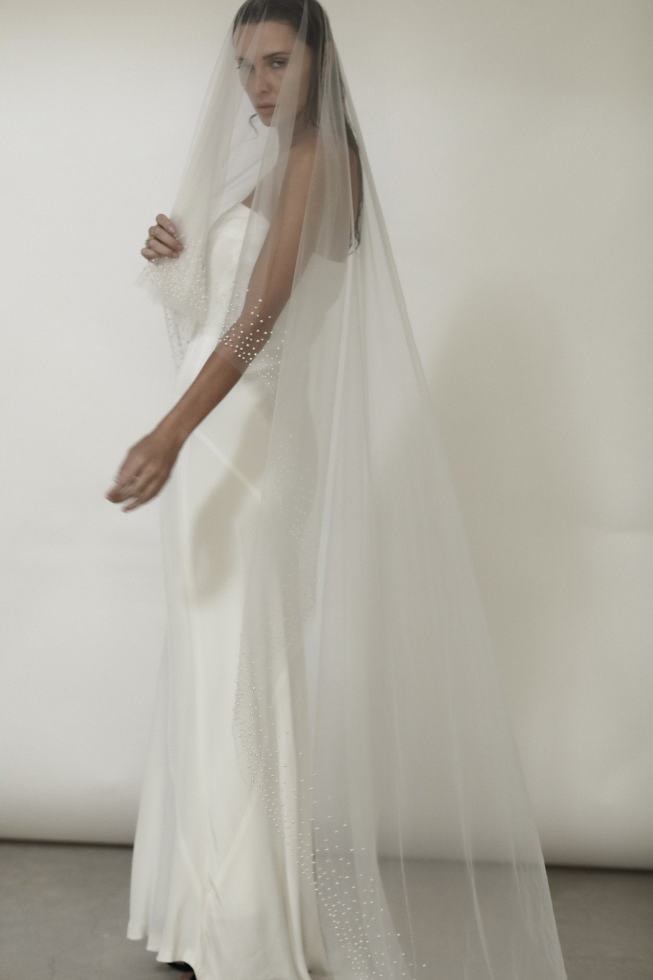 Model wearing the Hayden Pearl Edge Veil with a modern sheath wedding gown