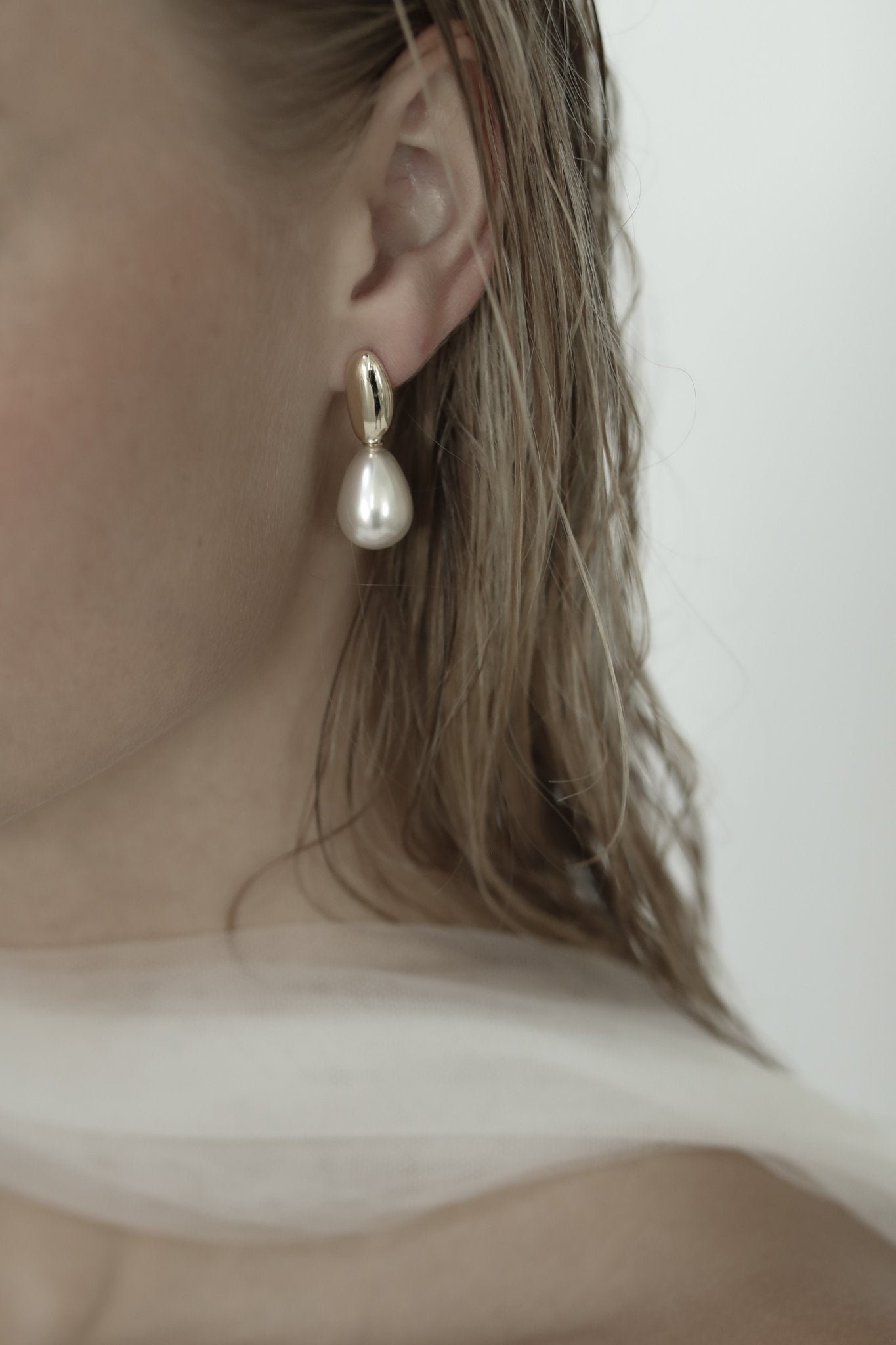 Close up of blonde bride wearing the gold pearl drop earring by AB Ellie