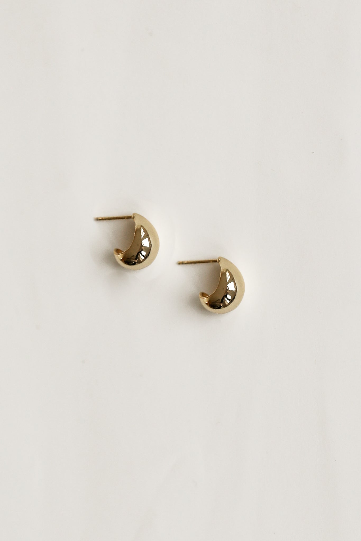 Flat photo of the gold micro orb earrings by AB Ellie on white background