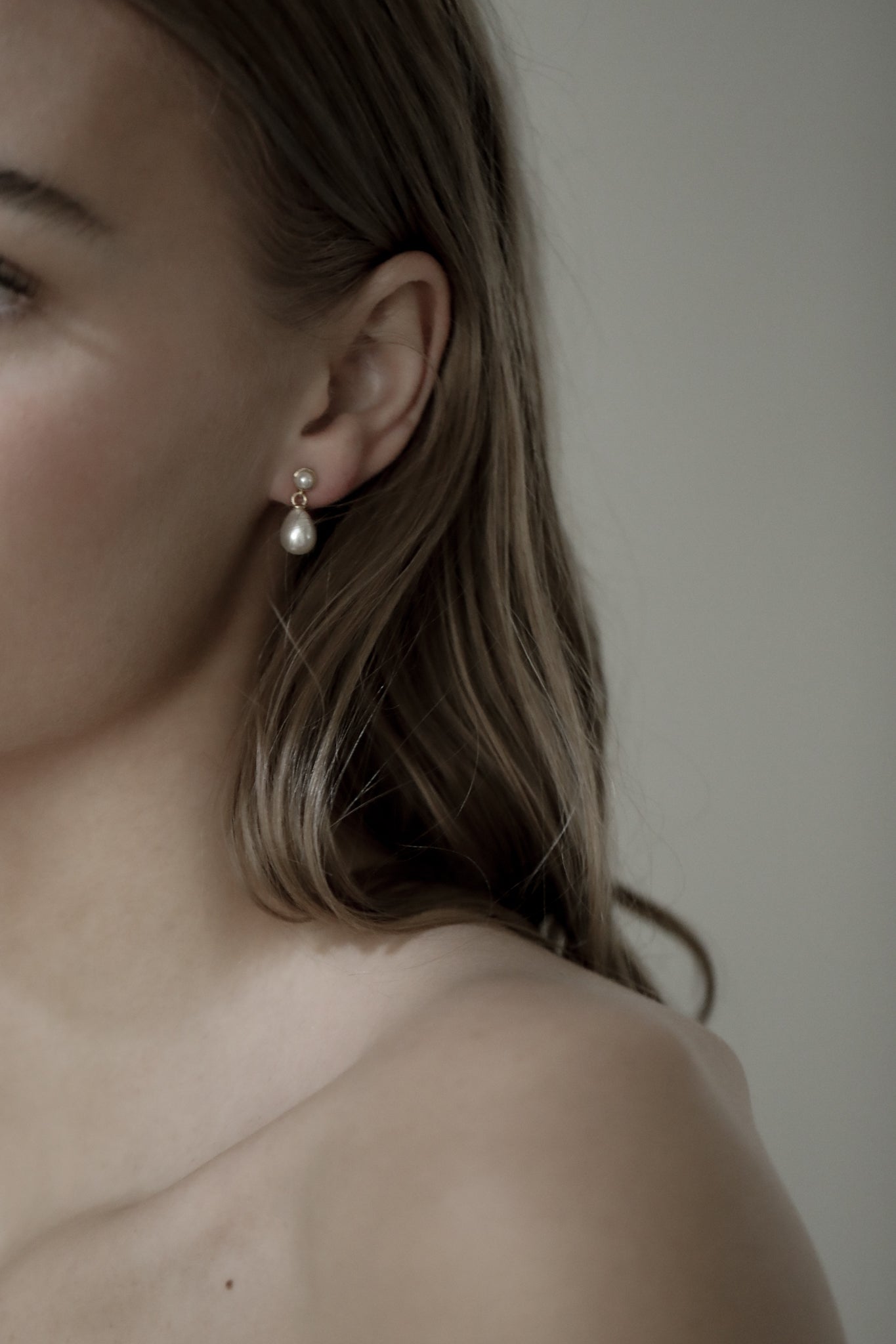 Photo of front left sife of sandy blonde bride wearing the micro pearl drop earrings by AB Ellie Studio Bride collection
