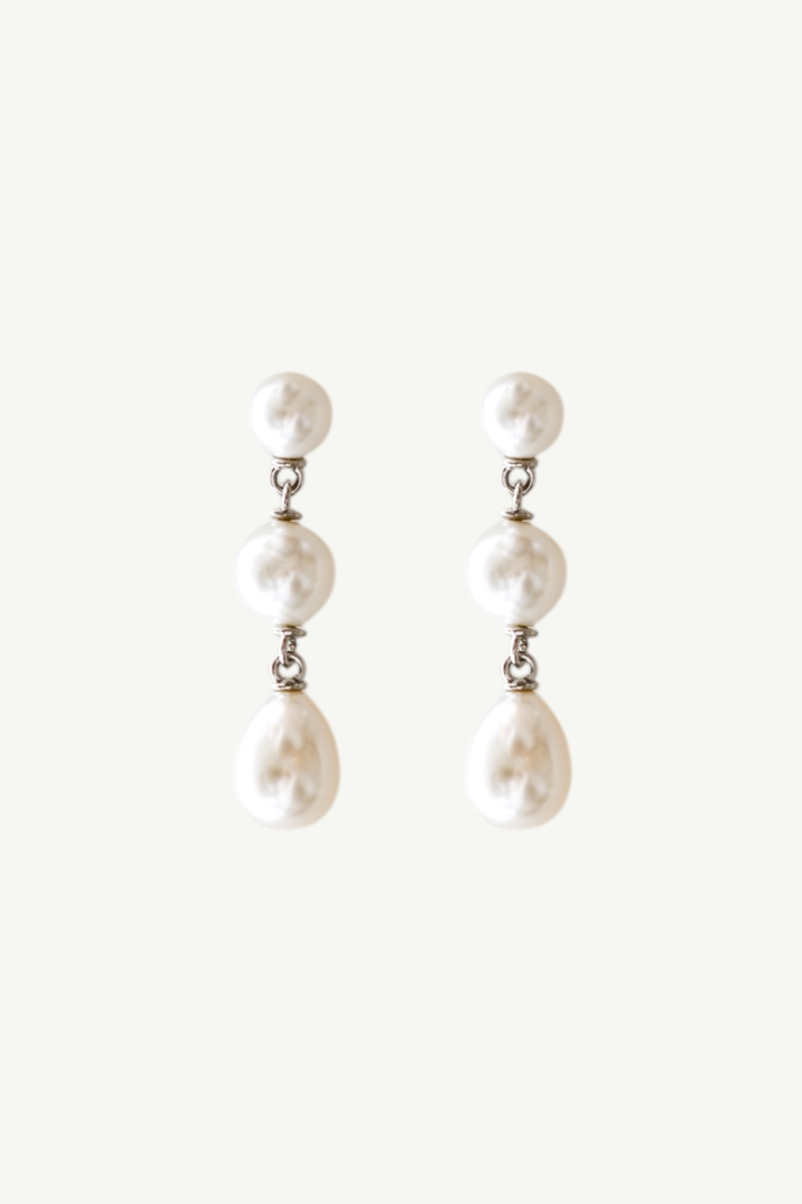 Flat photo of the silver pearl triple drop earrings by AB Eliie
