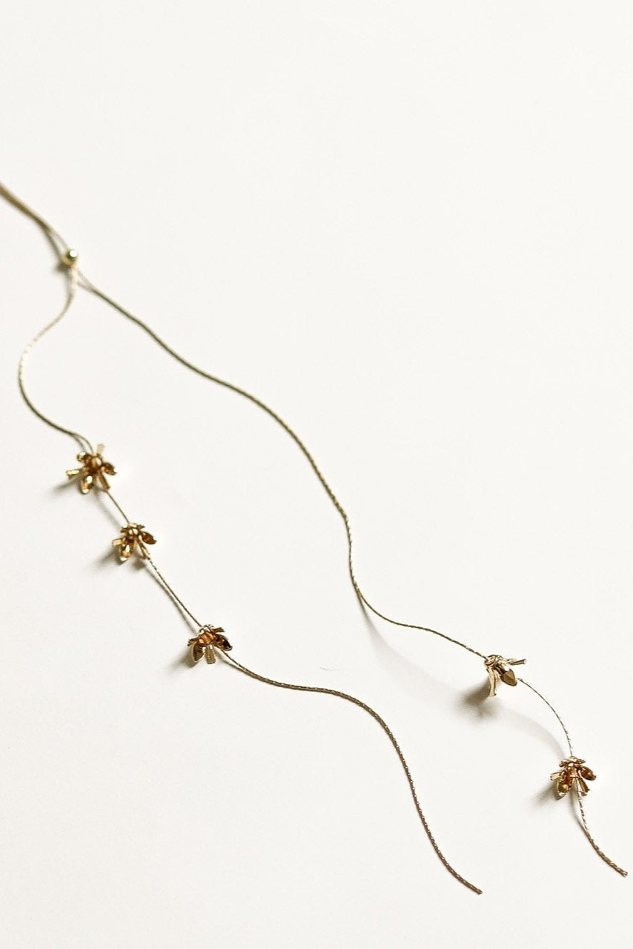 Close up floral detail of Rue lariat necklace by AB Ellie on white background