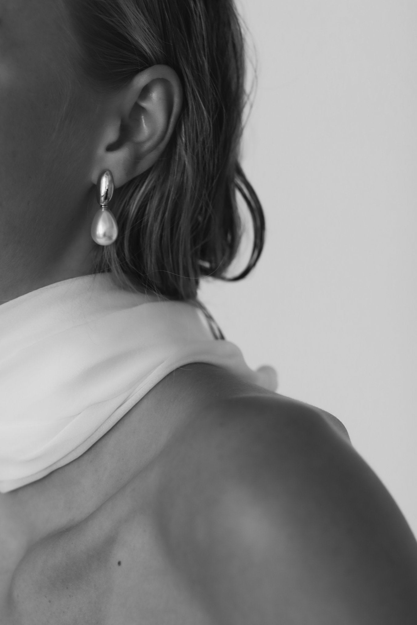 Black and white image of bride wearing the sliver pearl drop earrings by AB Ellie