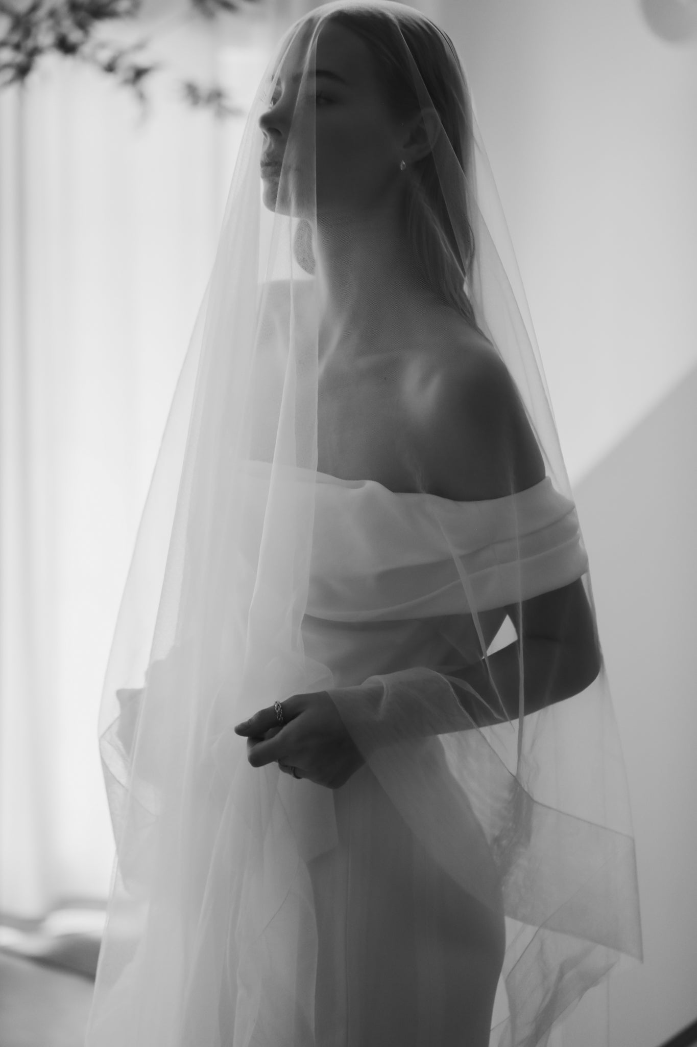 Bride wearing tulle edged wedding veil with blusher on white background by A.B. Ellie