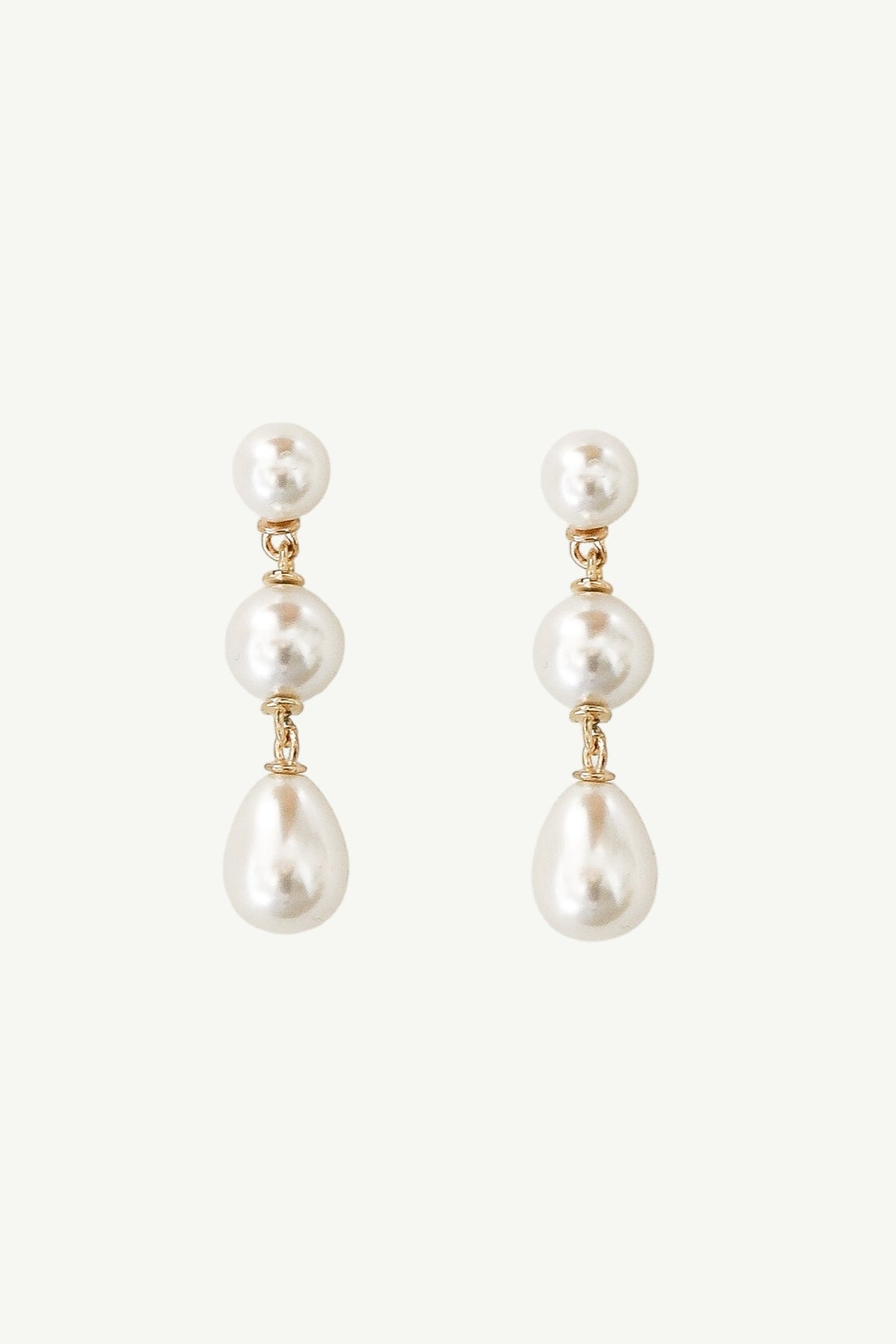Flat photo of the gold pearl triple drop earrings by AB Ellie on white background