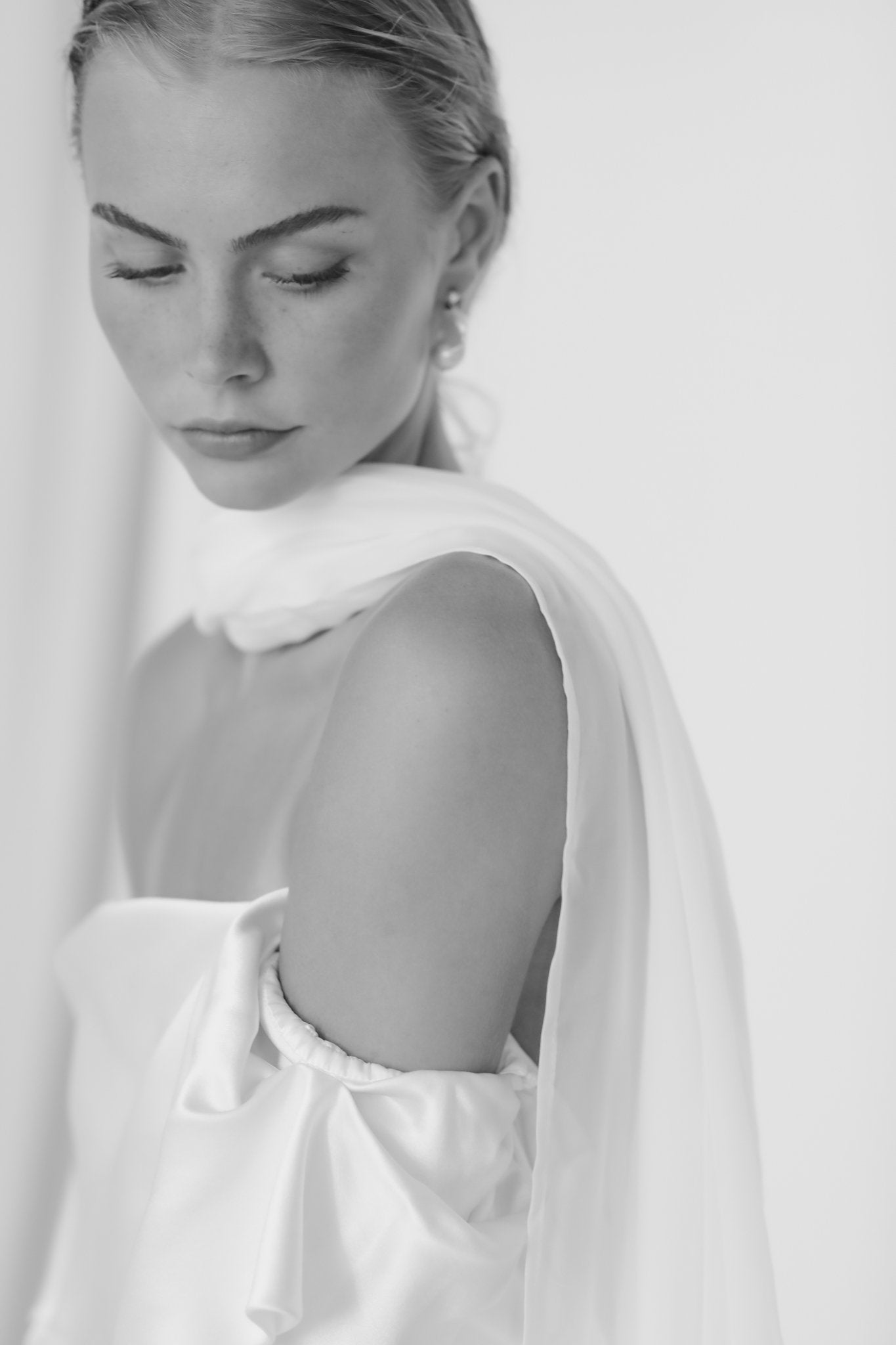 Black and white photo of bride wearing the statement baroque pearl drop earrings by AB Ellie paired with silk scarf and off shoulder dress