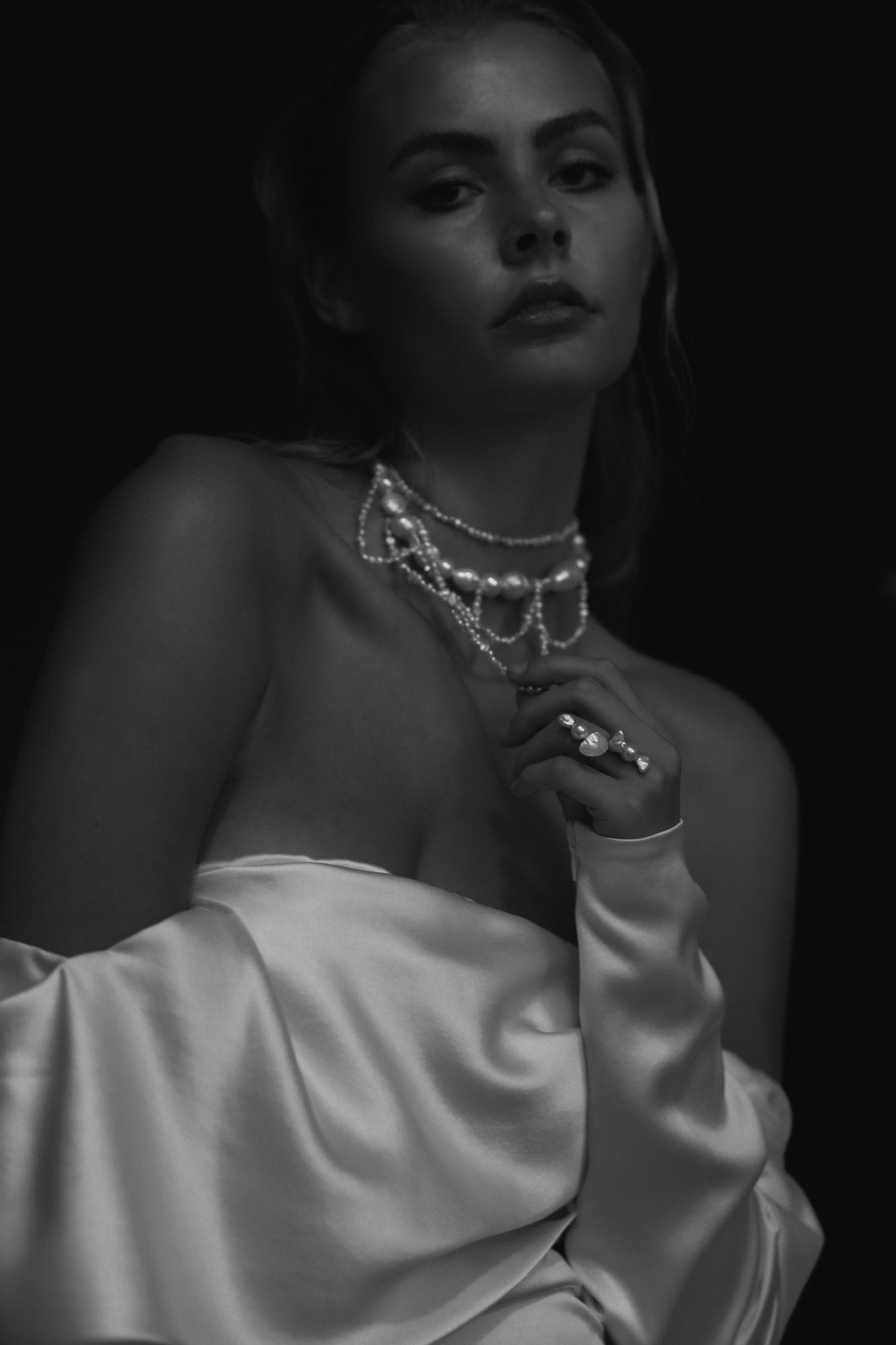 Black and white image of bride wearing the cascading freshwater pearl necklace by AB Ellie with an off shoulder dress