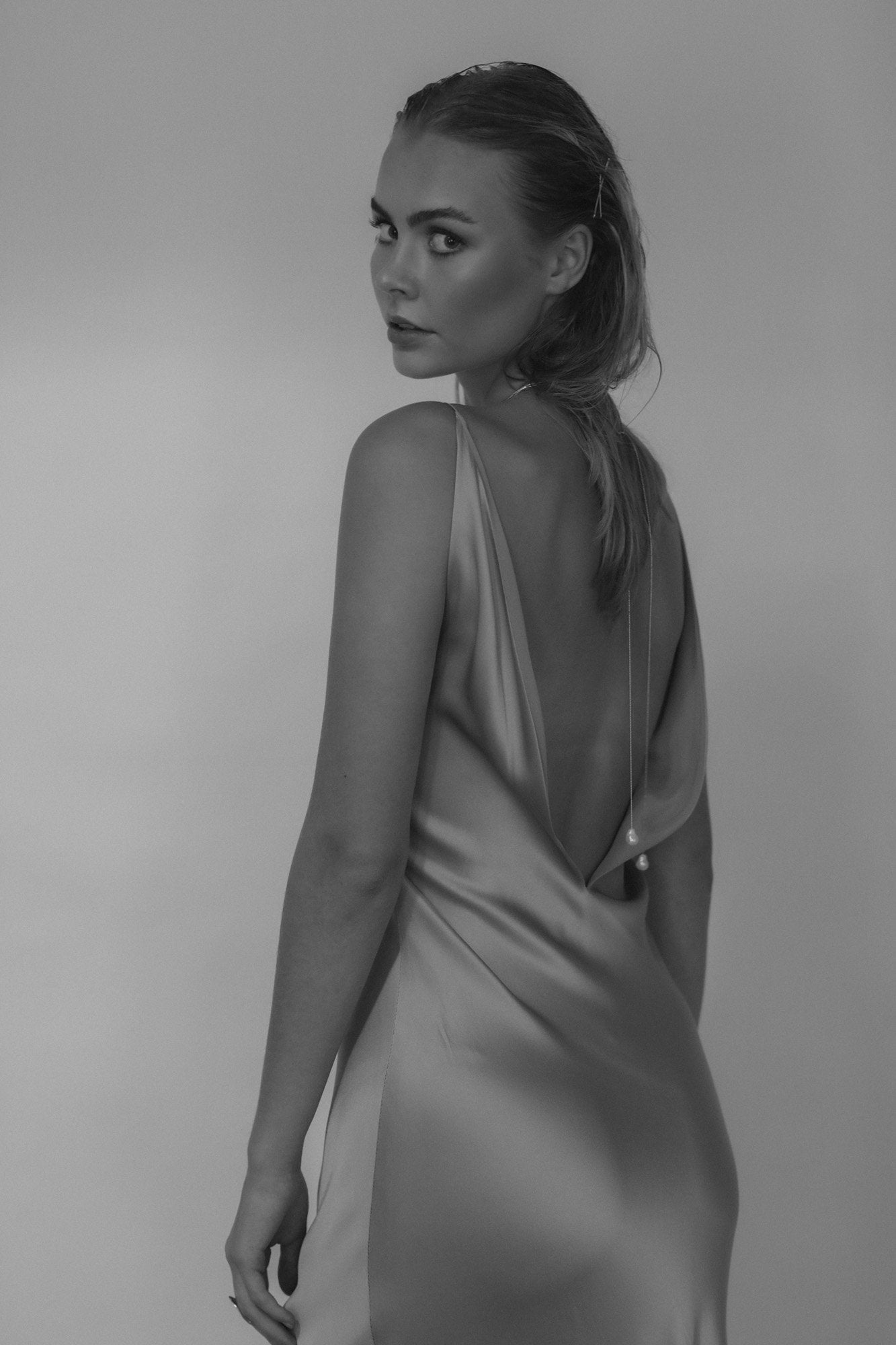 Black and white image of bride wearing a baroque pearl bolo necklace by AB Ellie, shown from the back