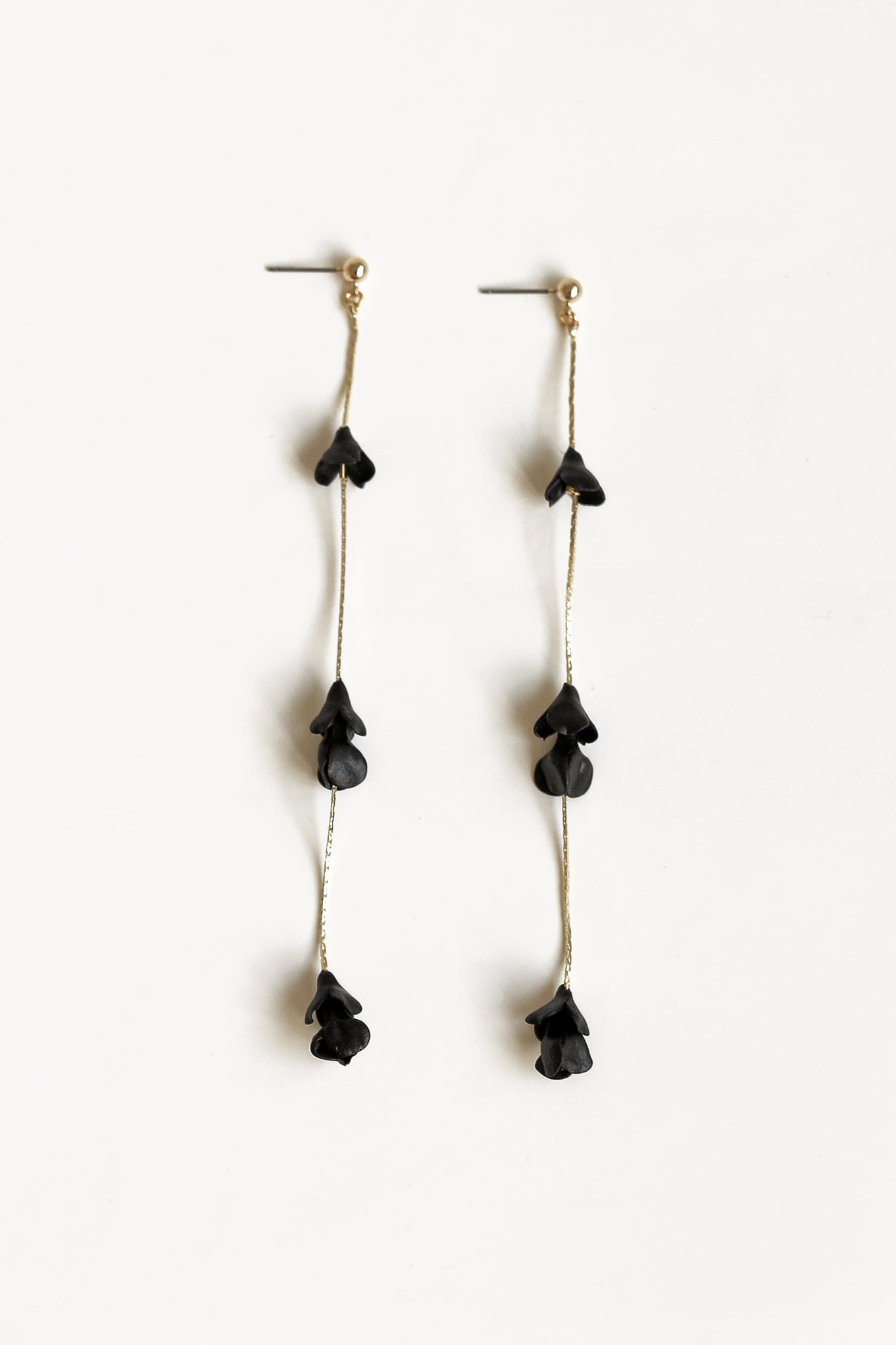 Flat photo of the Black blossom strand earrings by AB Ellie on white background