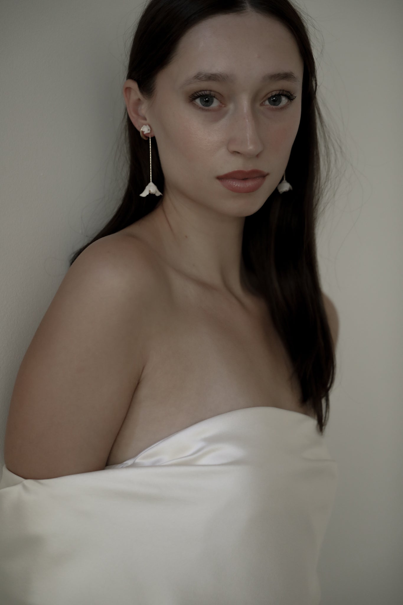 Photo of dark haired bride wearing the Blossom Strand two in one bridal earring by A.B. Ellie paired with an off the shoulder strapless wedding gown.