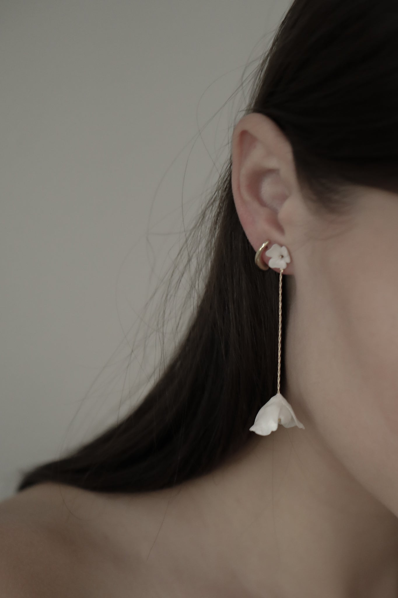 Close up photo of bride wearing the minimal Two in One ivory blossom flower strand earrings by A.B. Ellie 