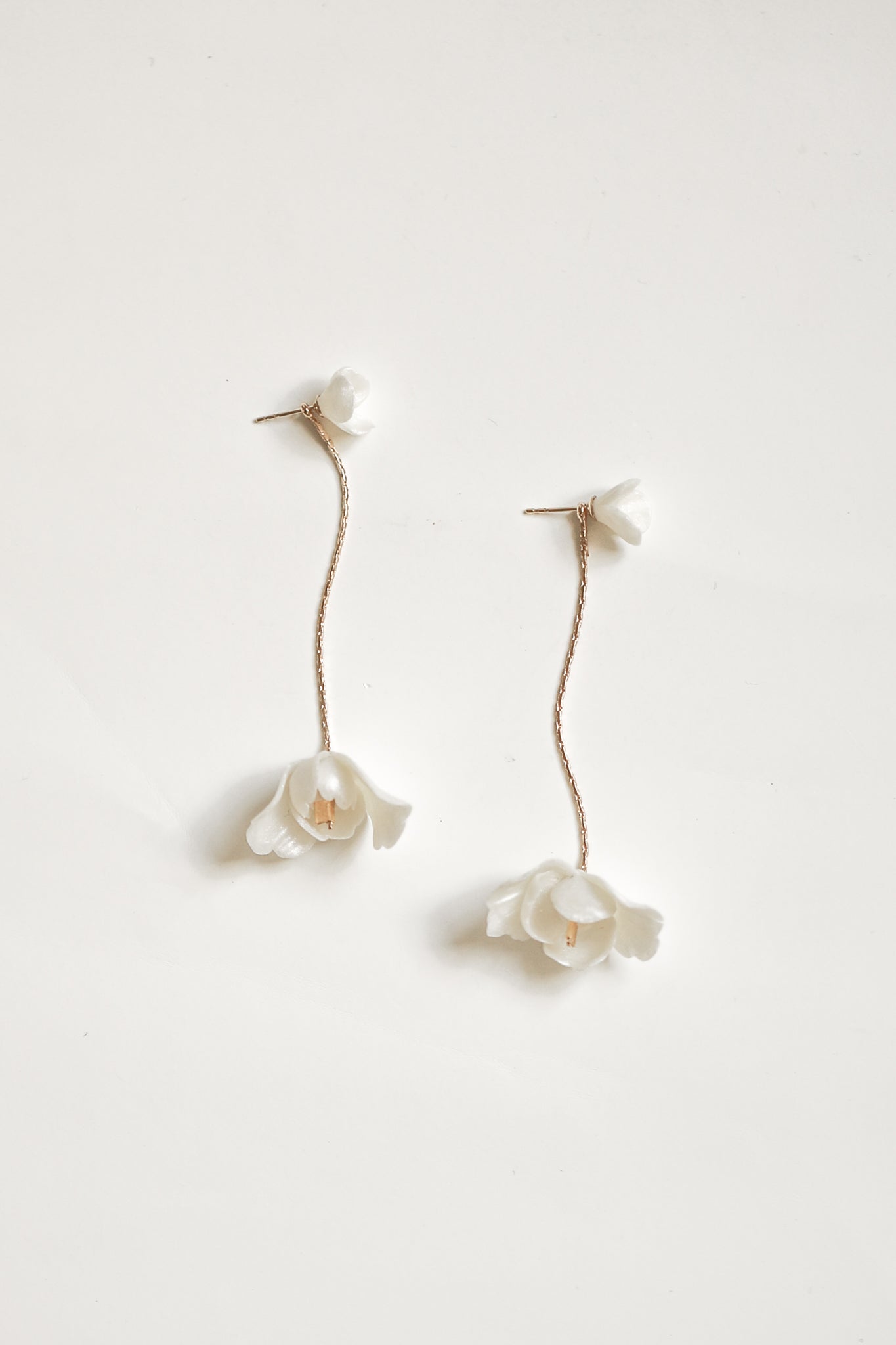 Flat photo of minimal ivory flower Blossom Strand two in one bridal earrings by A.B. Ellie 