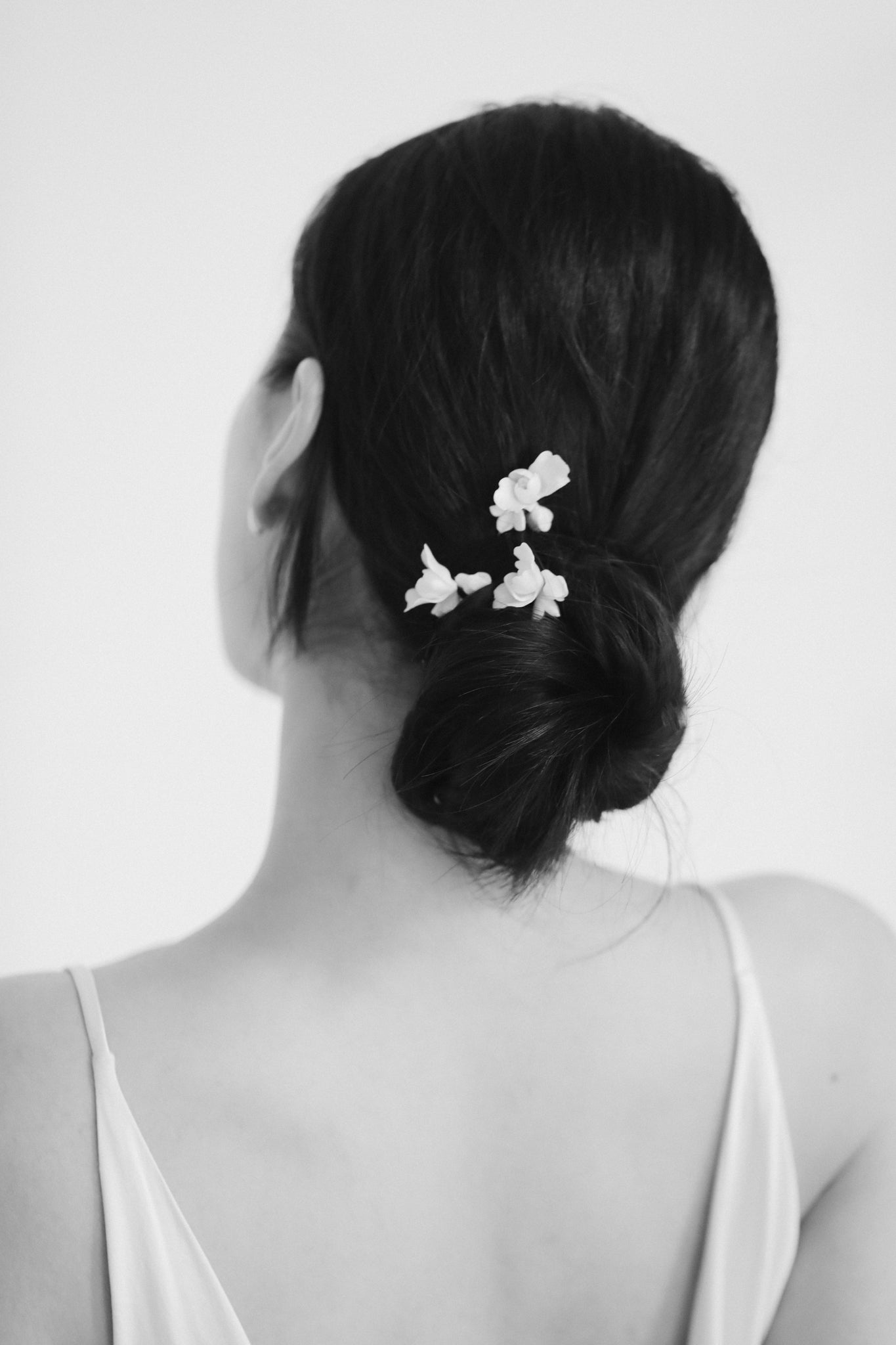 Black and white photo of bride wearing the blossom hairpin trio by AB Ellie with hair in bun