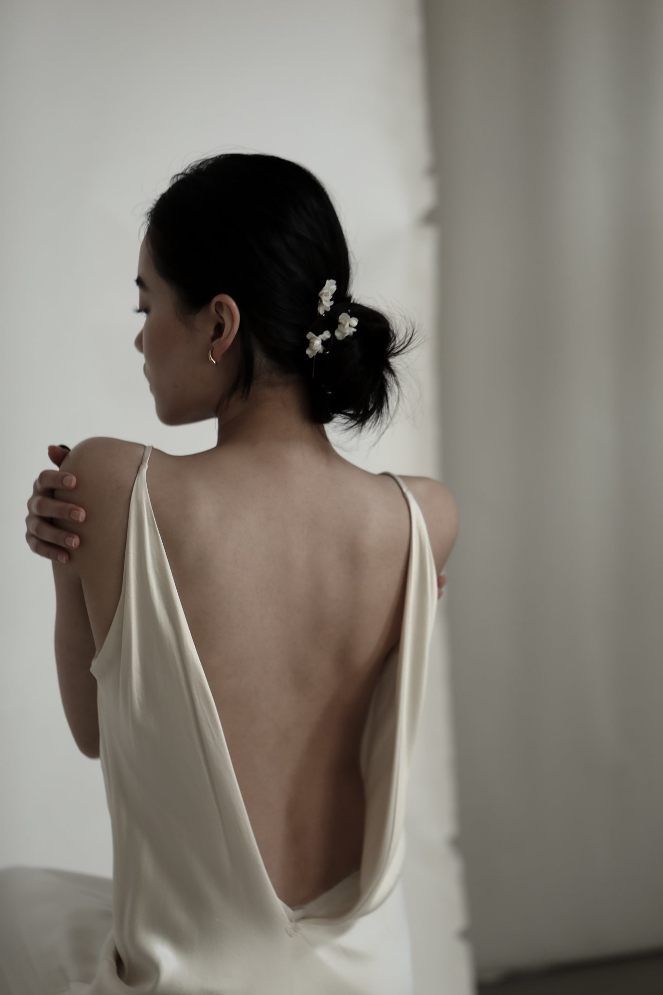 Photo of dark haired bride wearing the blossom hairpin trio by AB Ellie with an open back dress