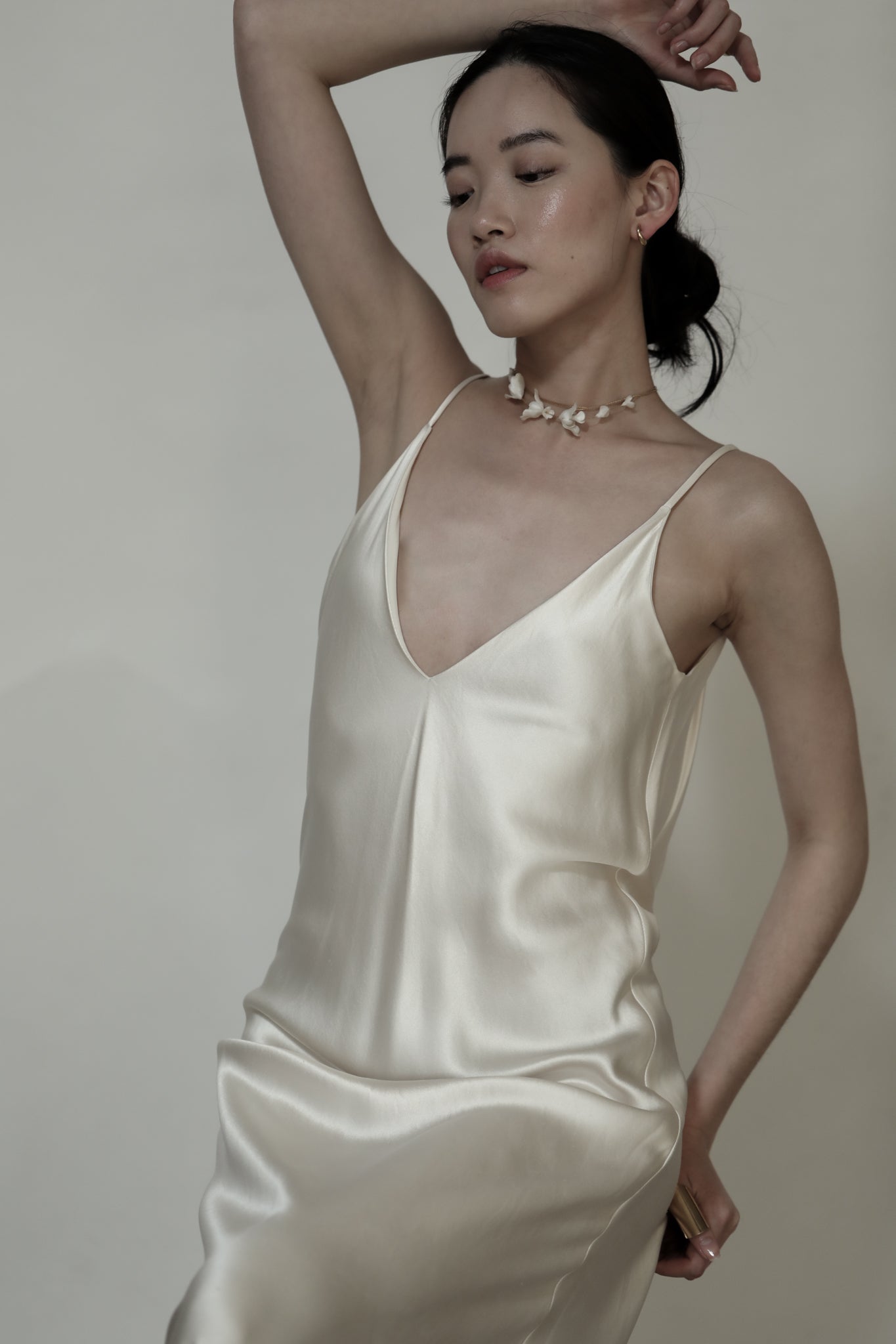 Bride wearing an ivory satin slip dress with the blossom floral wrap necklace against a white background