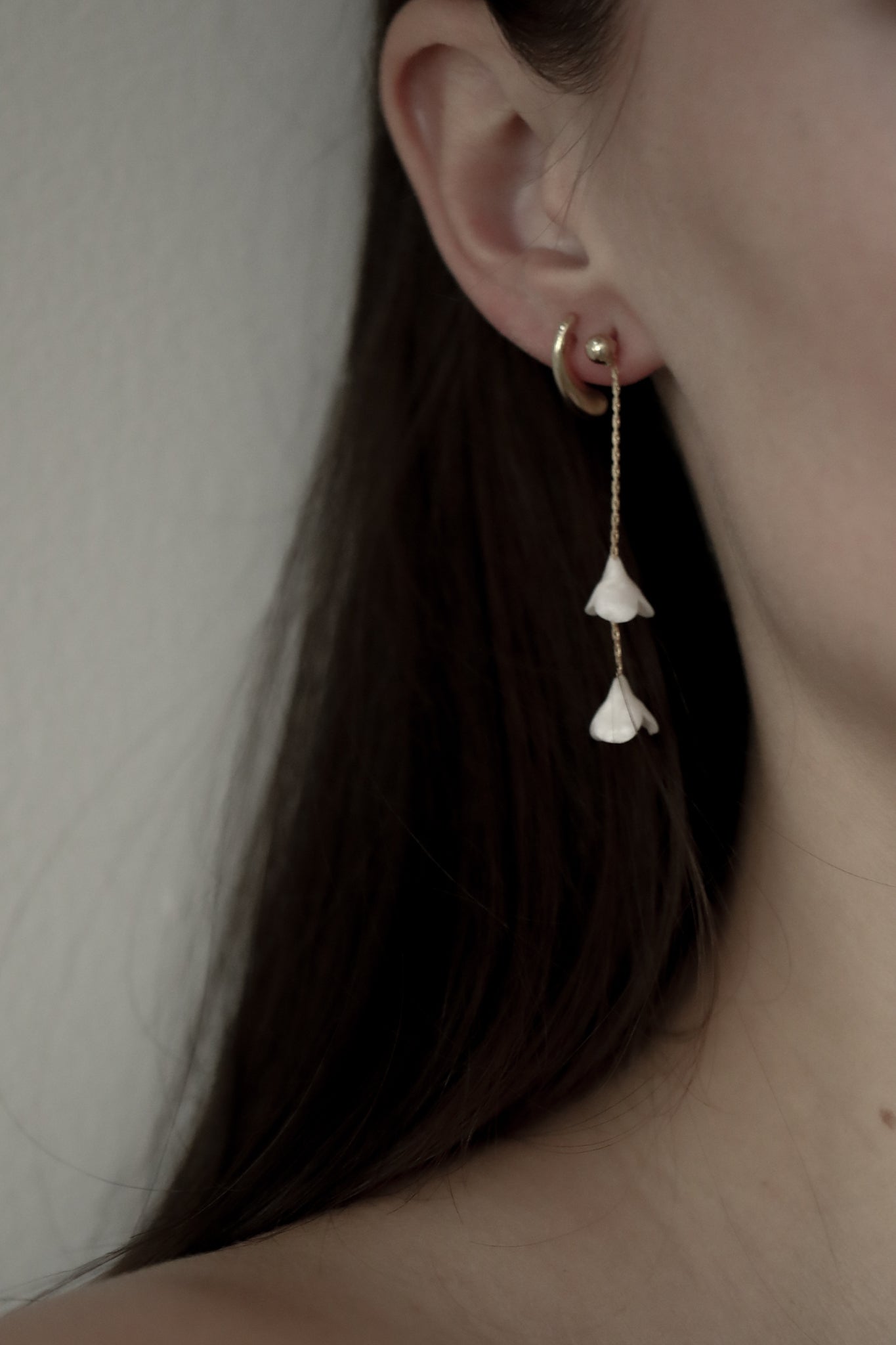 Close up photo of dark haired bride wearing the blossom minimal stand earrings by AB Ellie