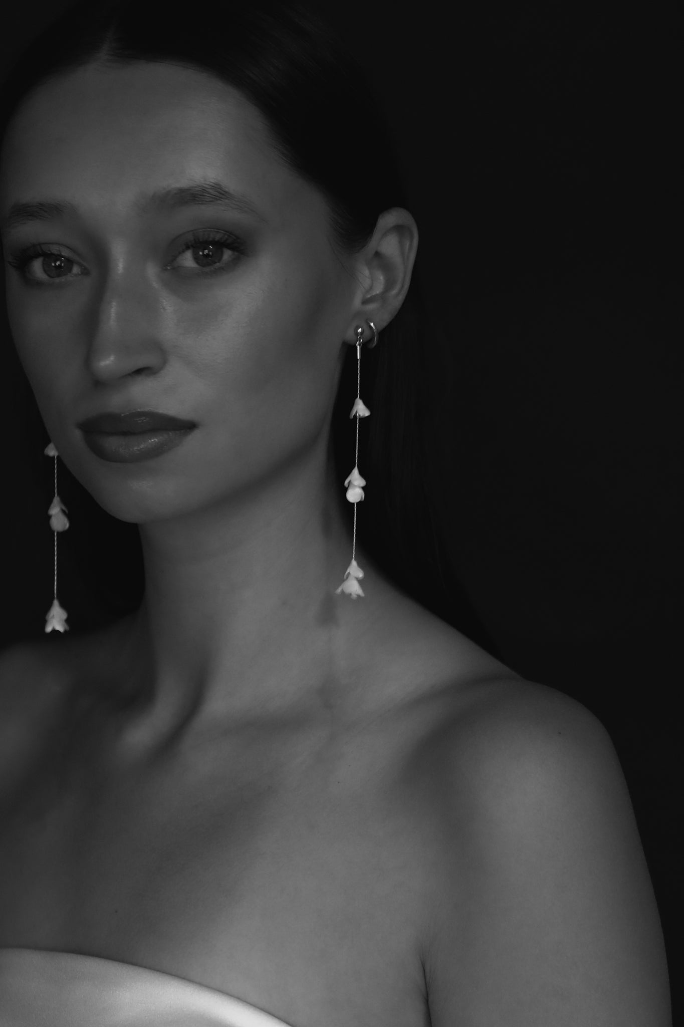 Font view black and white photo of bride wearing the blossom strand earrings by AB Ellie