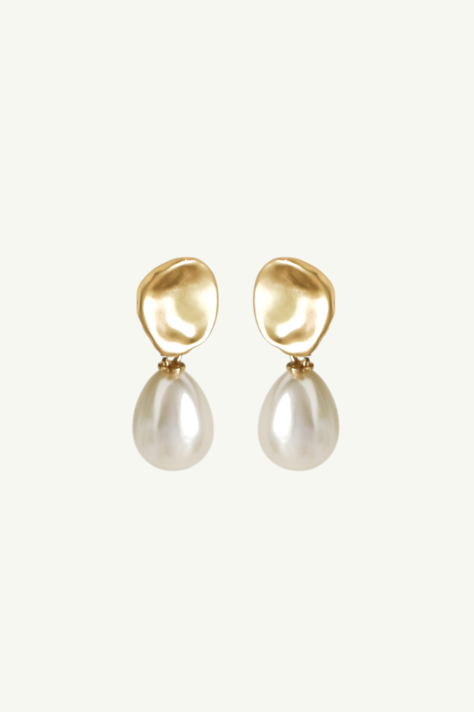 Flat photo of the clip on, gold sculptural pearl drop earrings by AB Ellie on white background