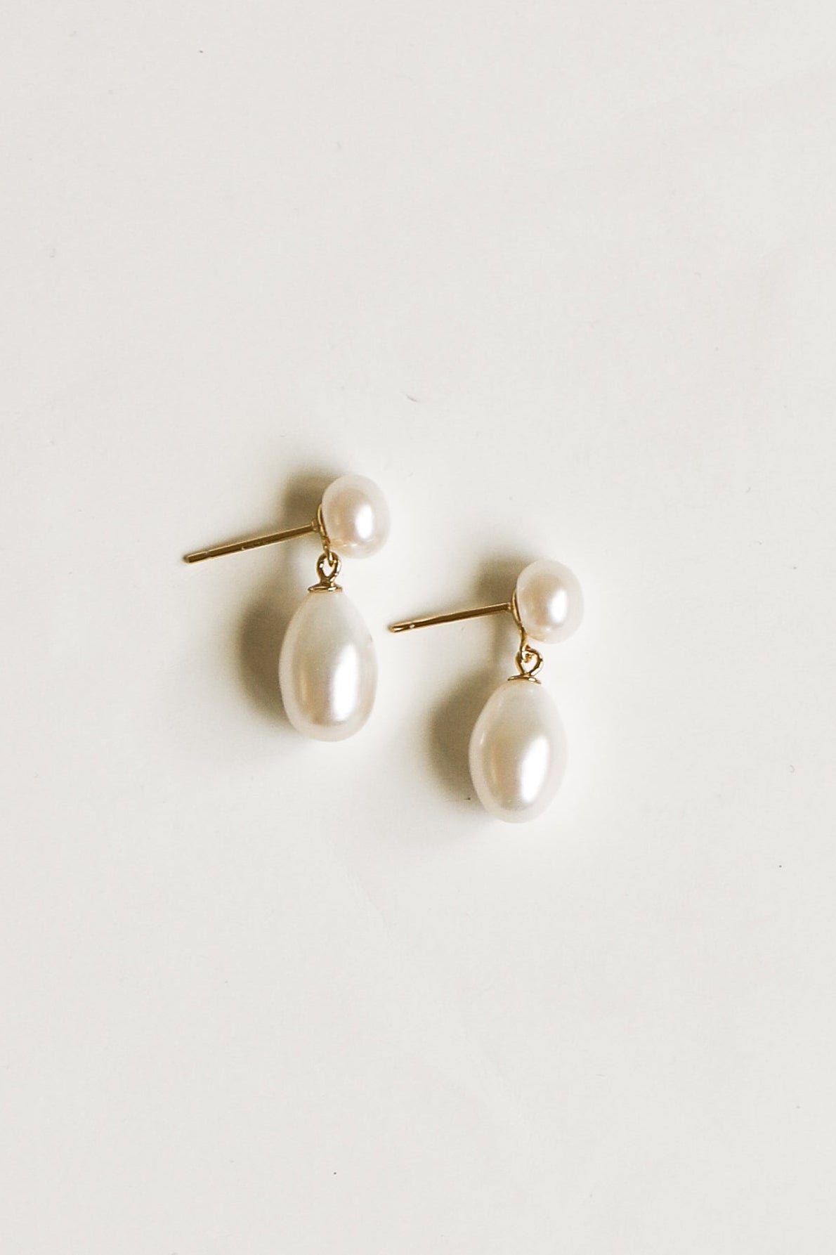Pair of pearl earrings on a light gray background