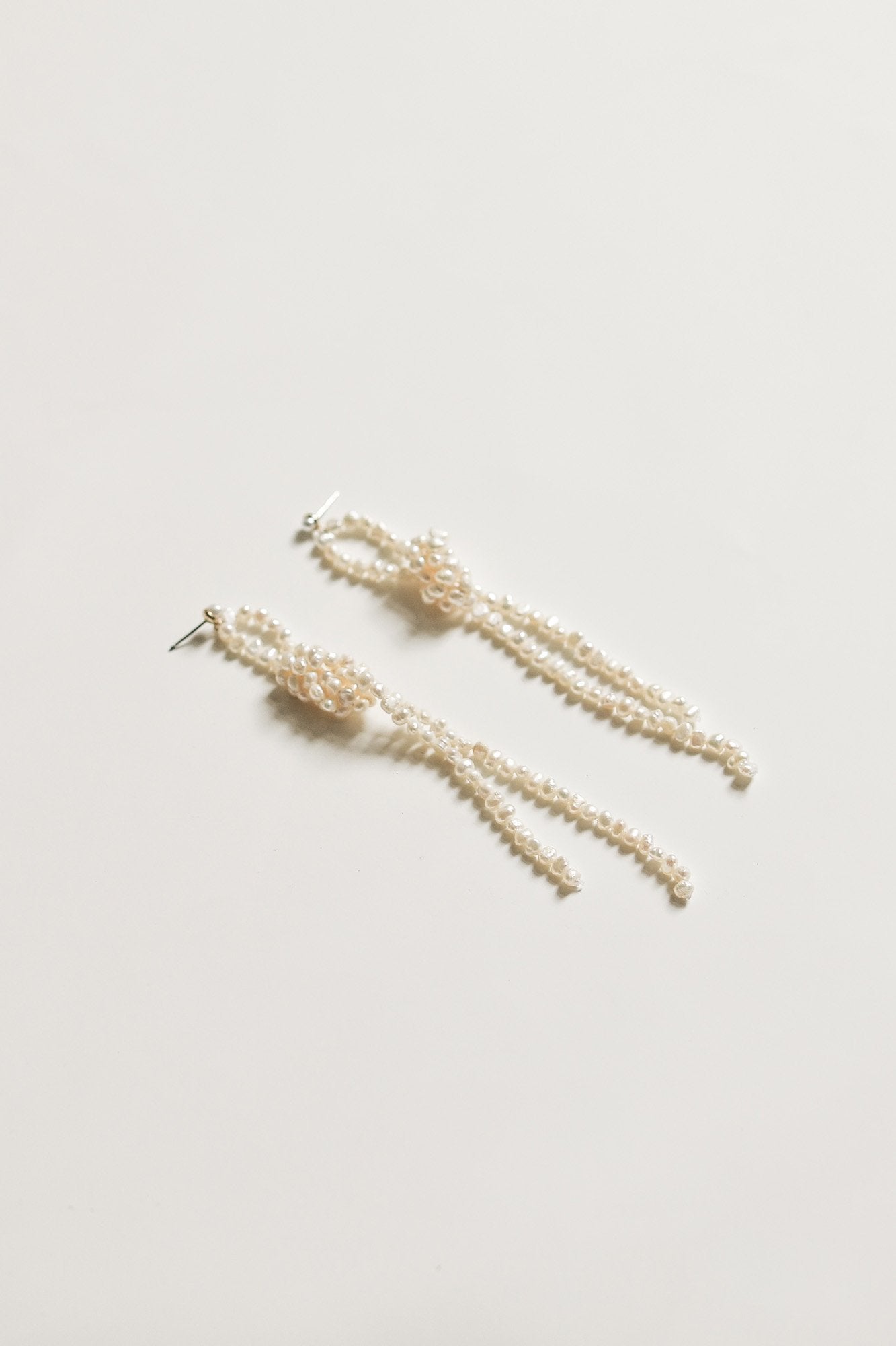 Flat angled photo of the knotted freshwater pearl earrings by AB Ellie on a white background